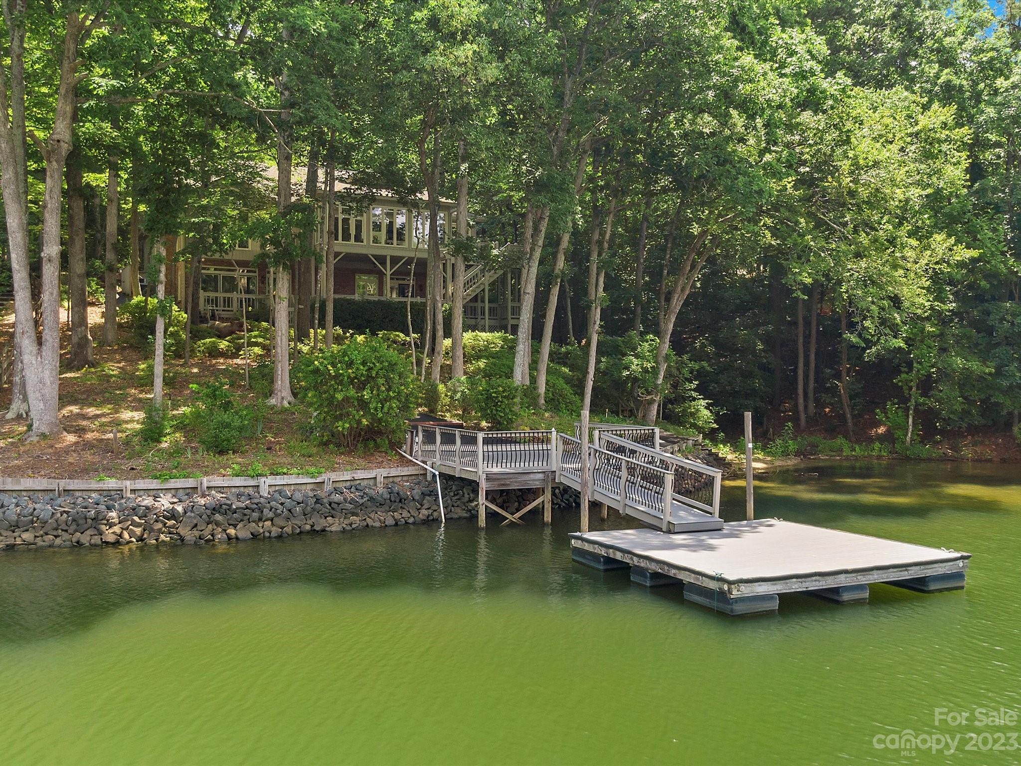 Welcome home to this amazing home in River Hills. You have everything you could ever want in this four-bedroom three and a half bath well kept home. Nestled in the trees giving you a tree house feel with plenty of privacy. This home offers something for everyone. You can start your mornings sipping coffee in the sunroom that overlooks the lake. The huge game room and wet bar downstairs make for a great man cave. Into growing your own herbs and vegetables, you can do that in the attached greenhouse.  Entertaining is a breeze with the large kitchen and large wrap-around covered deck.  Lake living, you have your own beach to launch paddleboards and kayaks along with a floating dock to keep your boat. Sports, head out and play a round of golf at The River Hills Country Club. All in a gated community with lots of different clubs and groups you can join. River Hills is close to many restaurants and just ten minutes from major shopping.
