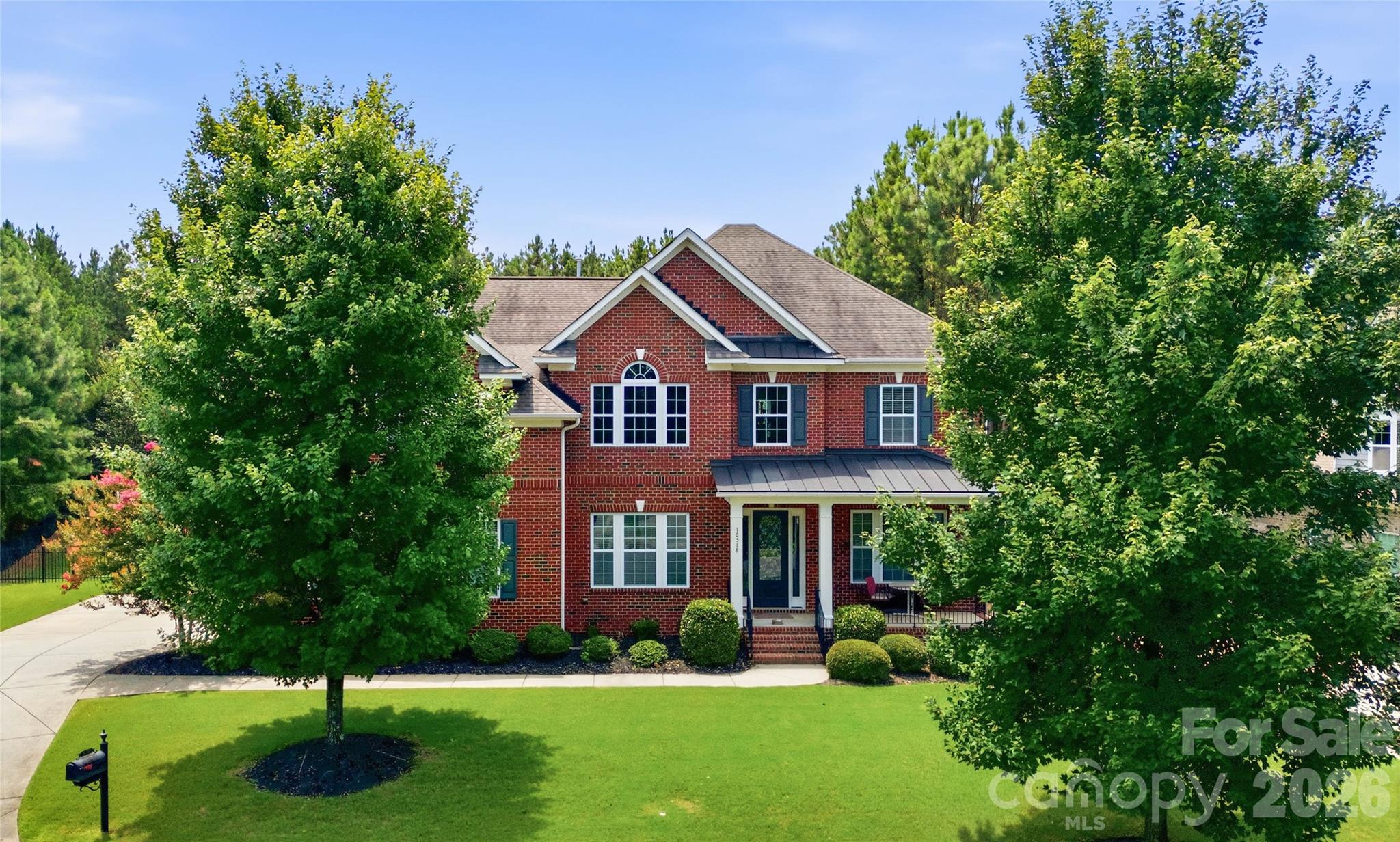 Located in the gated Eagles Landing community within the amenity-rich Palisades, this full brick home welcomes you with a charming covered rocking chair front porch and a grand two-story foyer. A private study with French doors sits just off the entry, while the gracious dining room across the foyer offers flexibility as a formal entertaining or receiving space. The gourmet kitchen is beautifully appointed with a gas cooktop, wall oven, ample skyline cabinetry, and an oversized prep island with a double-bay sink, seamlessly flowing into the breakfast area and inviting living space—perfect for everyday living and entertaining. Step outside to the stunning screened porch overlooking a serene, gated backyard. A main floor guest suite offers versatility as a secondary office or private retreat. Upstairs, the spacious primary suite features a tray ceiling, dual vanities, a soaking tub, a glass-enclosed shower, and a walk-in closet, while bedrooms two and three share a Jack-and-Jill bath, and bedroom four has access to a hall bath. A huge bonus room completes the upper level, providing endless possibilities for recreation or relaxation. Residents of The Palisades enjoy a true resort-style lifestyle with community amenities that include a clubhouse, pool, fitness center, tennis courts & miles of scenic walking trails. In addition, the private Palisades Country Club offers optional social and golf memberships, featuring a Jack Nicklaus-designed 18-hole golf course, elegant clubhouse dining, tennis complex, swimming facilities, fitness center, and a full calendar of social events designed to enhance an active and connected lifestyle