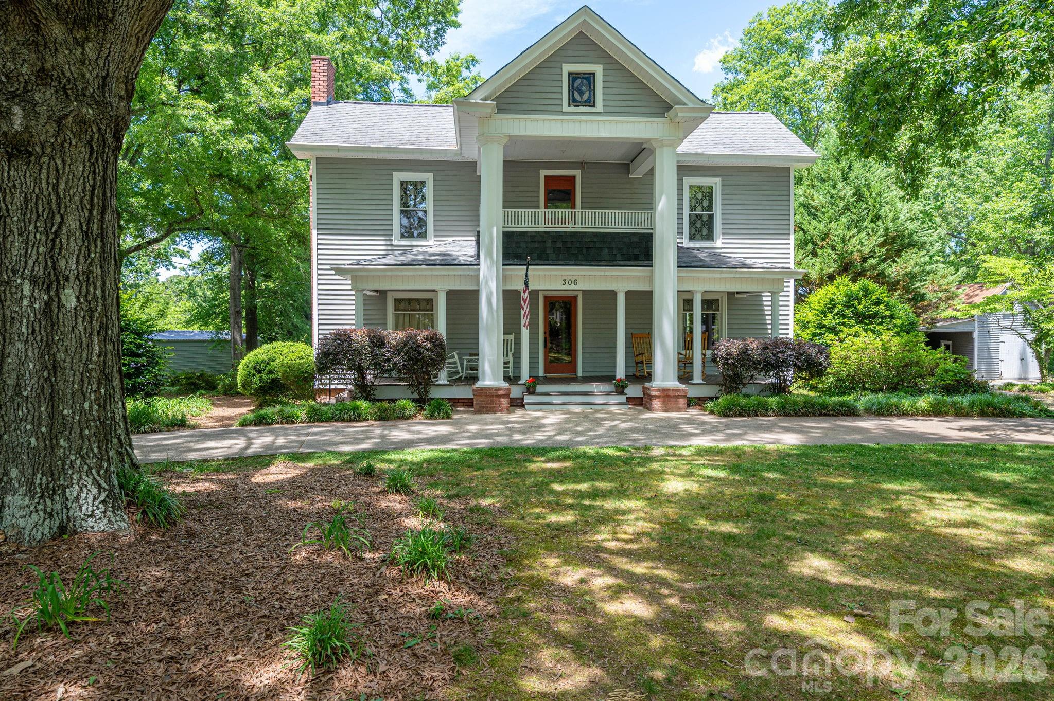 This lovely home embodies the best of early 20th century American architecture; a blend of late Victorian and Craftsman-influenced style boasting of stately classical columns and a wide full front porch. Irreplaceable stained glass adorns front, side and attic windows. The interior features spacious rooms with hardwood floors, high ceilings and wide baseboards. On the main level is the primary suite with private bath, a second full bath, large living, dining, kitchen, nook and laundry; 3 large bedrooms and balcony await upstairs. The kitchen has a new Thermador range and Thermador dishwasher, both installed in 2026. New HVAC 2023/2024. This home is a rare find - full of history, architectural integrity and character situated on .81 acre of mature trees, lush greenery and flowering bushes. Begin your new journey and create new memories in this vintage home!