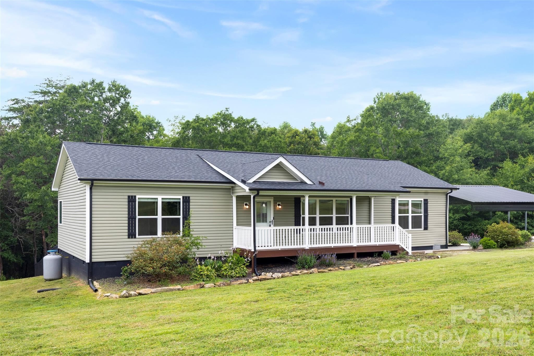 Move-in ready country living on 3.26 beautiful acres! This exceptionally maintained 2020 off-frame modular home on a permanent foundation offers the quality, comfort, privacy, and versatility today's buyers are searching for.

Inside, you'll find an open floor plan with luxury vinyl plank flooring, a spacious kitchen featuring a large island, generous cabinet space, and a desirable split-bedroom layout designed for privacy. The oversized primary suite includes a walk-in closet and an inviting ensuite bath with dual vanities, a soaking tub, and a separate shower.

Step outside and enjoy the peaceful setting from the covered front porch or rear deck overlooking the fenced backyard and mature woods beyond, providing exceptional privacy with no immediate rear neighbors. The property also features a powered detached metal building with built-in shelving, a versatile pole barn with covered equipment storage, and a detached metal carport with an EV charging station—offering exceptional flexibility for hobbies, projects, equipment, vehicles, gardening, or additional storage.

Located outside city limits with no city taxes, private well, and septic, this property offers the freedom and tranquility of country living while remaining conveniently located to Gastonia, Dallas, Lincolnton, and Charlotte.

If you're looking for a home that is truly turnkey, meticulously maintained, and offers room to spread out both inside and out, 1259 Hardin Road deserves a spot at the top of your list.