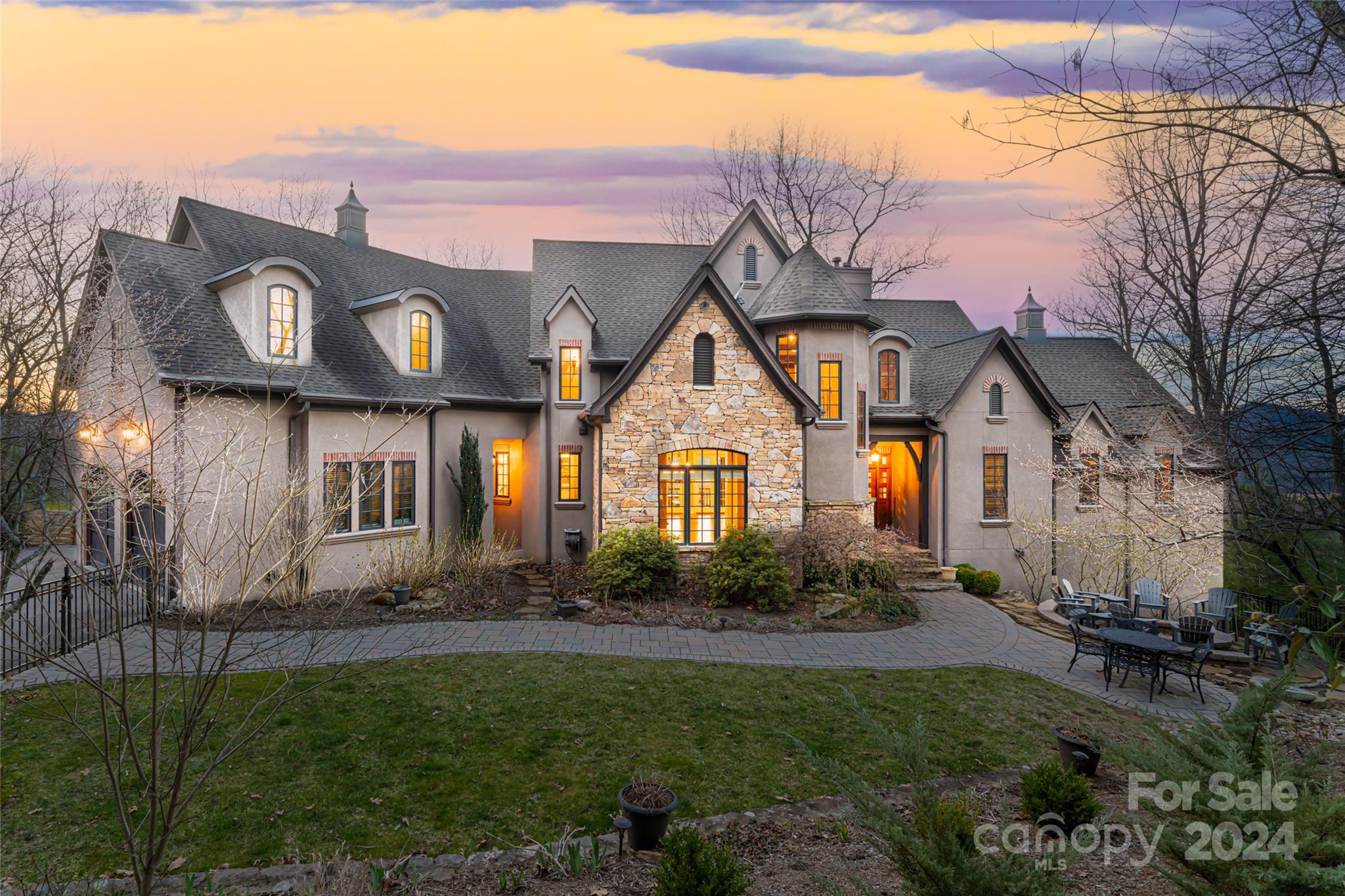 Escape to your own private sanctuary in gated Scotts Ridge in Biltmore Lake. Perched on 3+- Acres, this custom home offers an unparalleled level of tranquility, panoramic views and privacy. Upon arrival, the grandeur of the residence is immediately apparent, with soaring ceilings and floor-to-ceiling windows in the great room that capture panoramic vistas. The gourmet kitchen offers top-of-the-line appliances, custom cabinetry, and a spacious dining area. The main level primary suite boasts double closets, a spa-like bathroom and grants access to the covered deck. Outdoor living is elevated to an art form, with expansive decks spanning multiple levels, providing ample space for relaxation and entertaining. The upper level of the home hosts 2 bedrooms and a media room. The terrace level is a haven for entertainment, featuring a large family room, 2nd primary bedroom, and a versatile sport court that currently houses a golf simulator, previously utilized as a half-court for basketball.