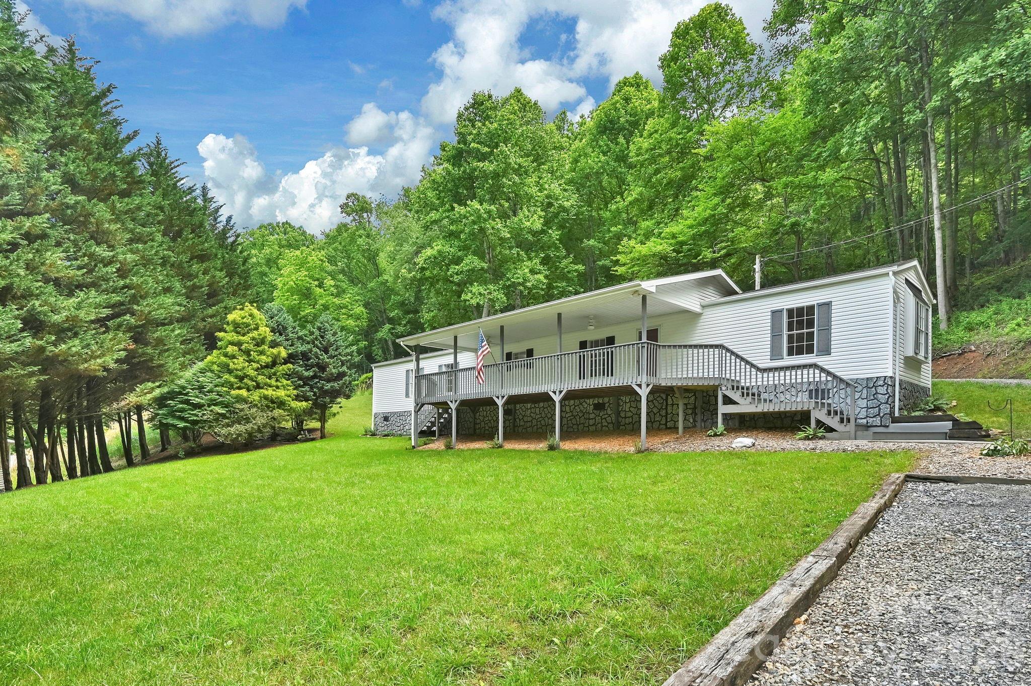 Tucked away in the peaceful countryside, this charming single wide mobile home offers comfortable country living with plenty os outdoor space to enjoy. The home features a small addition off the master bedroom that adds extra flexability for a cozy den, office or guest space. Outside, you will find a large detached building providing ample covered parking, storage or workshop potential.
The property boasts a beautiful flat front yard that is easy to maintain and perfect for pets or outdoor gatherings. A relaxing water feature adds to the serene setting, creating a quiet retreat where you can unwind and enjoy nature. One of the standout features is the huge covered front porch (34x10), offering the ideal space for entertaining or simply enjoying your cup of morning coffee.
Whether you are looking for a full time residence, rental opportunity, or weekend getaway, this property combines country charm, usable outdoor space and practical amenities in a tranquil rural setting.
Some of the updates are fresh paint, new carpet, new luxury vinyl, new countertops, updated baths, new furnace, new hot water heater, and waterfall feature with lights and pump and new fans and lighting in bedrooms.
This home is just a few miles from Mars Hill or Marshall and a short drive to Weaverville.