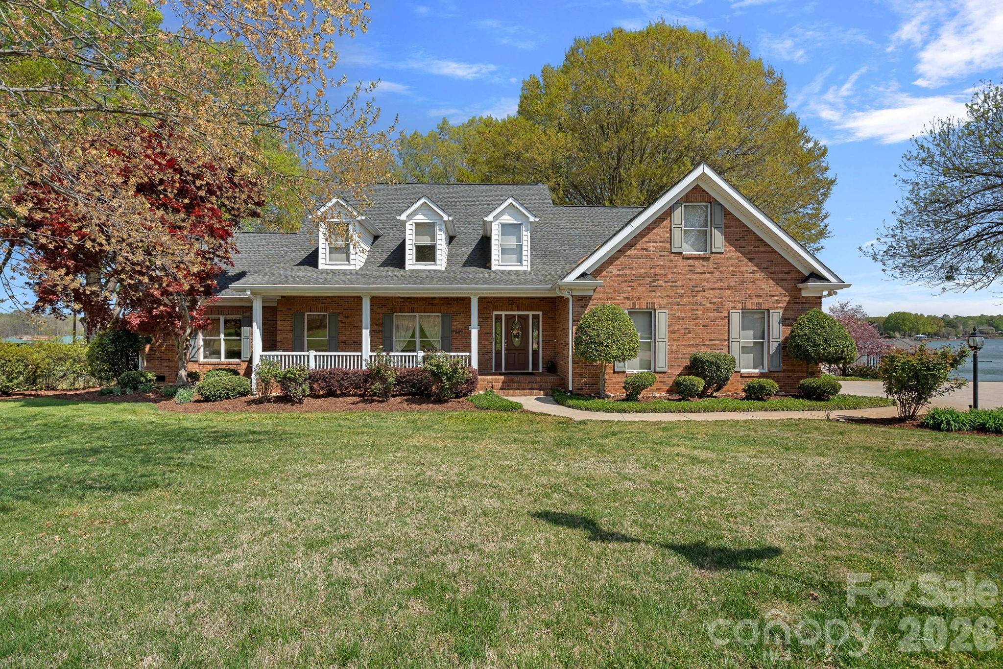 Meticulously maintained brick home with a 2 car attached and a 3 car detached garage for the automobile enthusiast and/or the ones that enjoy gardening and canning!  The detached facility has a kitchenette and bath with shower.  Walls of windows that bring the lake views in all year long! Primary suite has access to a large screened porch and patio. The covered pier/dock and lift are situated to a corner of the lot to allow for an unobstructed view of the lake!