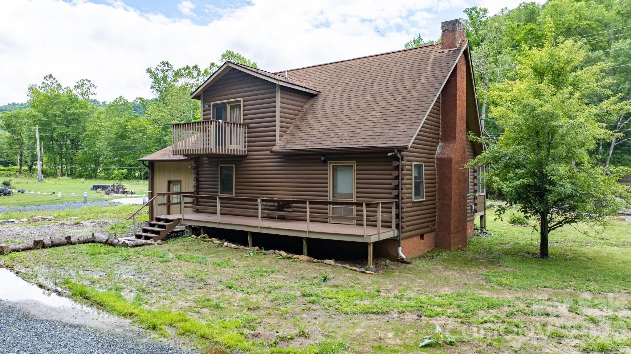 The sound of Little Rock Creek sets the tone for life at this mountain cabin retreat, where rushing water, mature trees, and scenic valley views create a setting that feels miles away from the pace of everyday life. Relax on the screened porch overlooking the creek, listen to the water flow over the rocks below, and enjoy the natural beauty that surrounds the property year-round.

Inside, the 3-bedroom, 2-bath home blends rustic character with thoughtful updates. A fully remodeled kitchen features custom countertops and all-new appliances, while the dramatic vaulted living room showcases soaring ceilings, wood floors, and a stone fireplace that anchors the heart of the home. An upstairs bedroom opens to a private balcony, offering another peaceful spot to take in the surrounding landscape.

Apple and pear trees add seasonal charm to the property, while the outdoor living spaces make it easy to enjoy the sights and sounds of the creek. Whether you're looking for a full-time residence, mountain getaway, or investment opportunity, this property offers a unique combination of comfort, character, and an exceptional creekside setting.