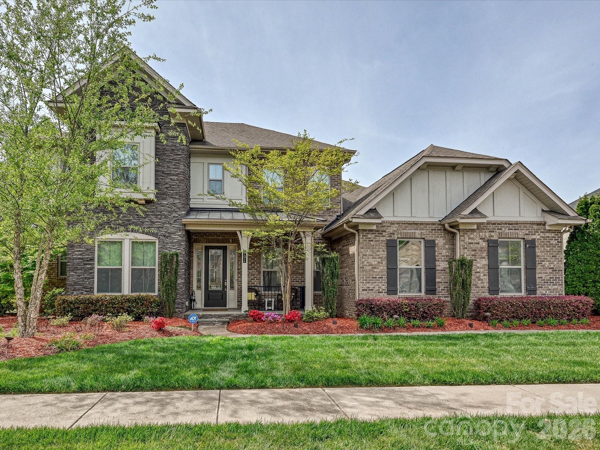 NEW FANTASTIC PRICE!!!
This home below 1.3M is an incredible deal. 
Welcome to unparalleled luxury in the highly sought-after Falls at Weddington, zoned for a highly rated, top-tier school district. As a former model home, this stunning full-brick estate masterfully blends sophisticated elegance with a warm, inviting ambiance, featuring a premium speaker system integrated throughout the home for effortless entertaining. The expansive main level boasts a seamless open floorplan, featuring a breathtaking gourmet kitchen with a sprawling island and walk-in pantry that flows effortlessly into the breakfast area and a magnificent great room anchored by a cozy fireplace. Entertain in the formal dining room or work with ease from the dedicated executive office. The lavish primary suite, conveniently located on the main floor, offers a private oasis complete with spa-like finishes and expansive walk-in closets. An additional main-level bedroom and full bath provide ideal, accessible accommodations for guests.

Ascend to the upper level to discover three generously sized bedrooms, two full bathrooms, and a versatile media room perfect for private movie nights. Step outside to your serene exterior retreat featuring a beautifully crafted screened-in porch and an open patio. The meticulously manicured, level backyard is effortlessly maintained by an in-ground irrigation system. Complete with a pristine 3-car side-load garage, an expansive laundry room with a drop zone, and access to resort-style community amenities including a clubhouse, fitness center, and pool. This is more than a home; it's a lifestyle.