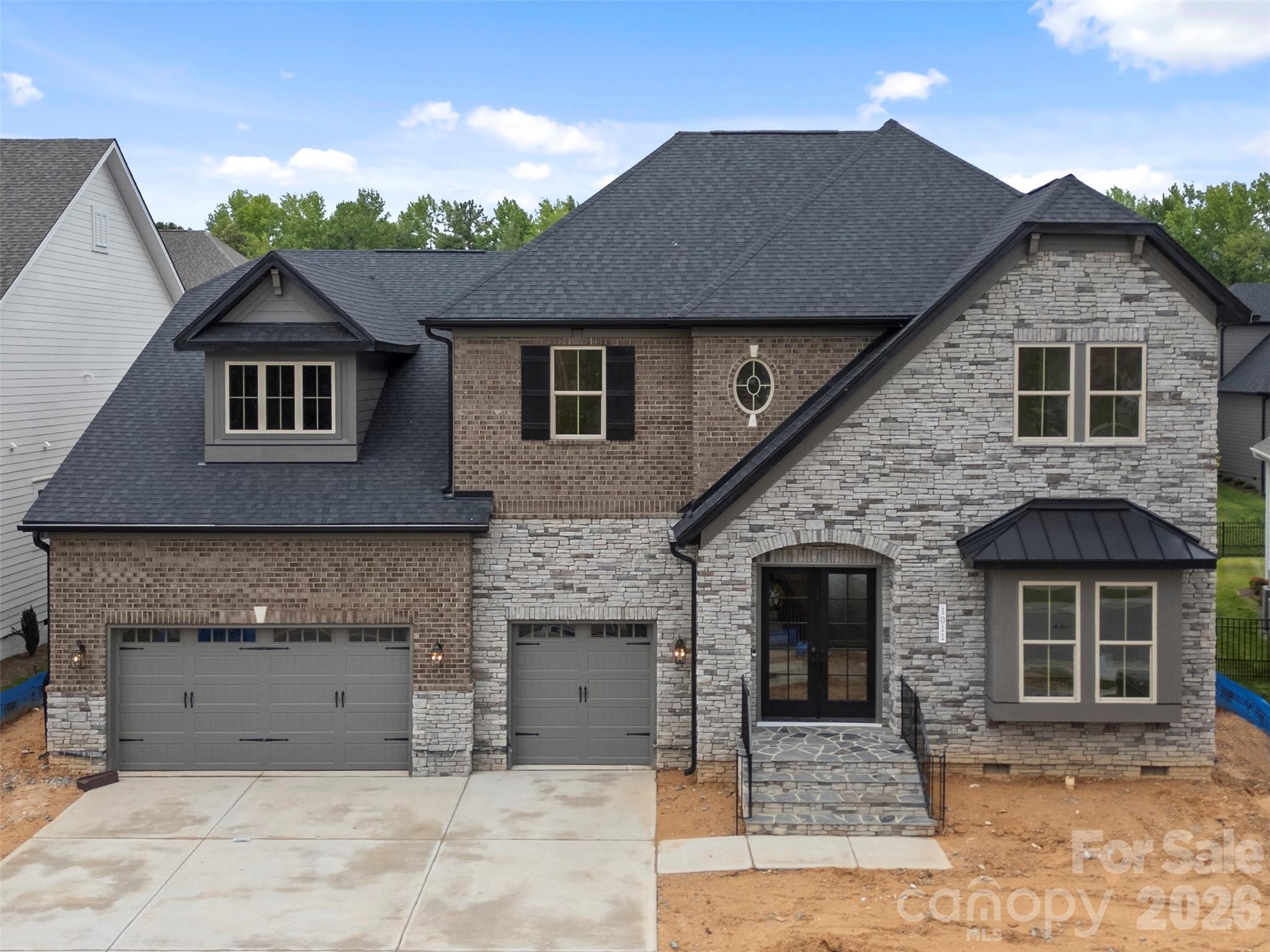 New construction luxury home in Heritage at Marvin, scheduled for completion March 2026. The Summerville floor plan offers approximately 5,155 heated square feet with 6 bedrooms, 6.5 baths, and a 3-car garage.
The main kitchen features stacked cabinetry, quartz waterfall island, full-height quartz slab backsplash, pot filler, brushed gold hardware, and a premium appliance package including a 42-inch built-in refrigerator, 6-burner gas range, custom hood, and wall oven/microwave combo. A separate messy kitchen provides additional prep space, storage, and secondary refrigeration.
Interior features include a built-in sports bar with island, glass-enclosed wine room, bonus room, and media room. The family room includes a linear fireplace with decorative tile surround, floating wood mantel, and built-in window seating with storage.
The primary suite includes a spa-style bath with soaking tub, oversized walk-in shower with rain head and handheld, quartz countertops, and designer tile selections. Secondary bathrooms offer quartz countertops, tiled showers, and comfort-height fixtures. Don't miss this!
Additional features include engineered wood flooring, upgraded drop zone, solid-core interior doors, black interior hardware, custom millwork, and designer lighting. Outdoor living spaces include a covered composite lanai with privacy wall and an upper-level covered rear balcony. Price and availability subject to change.