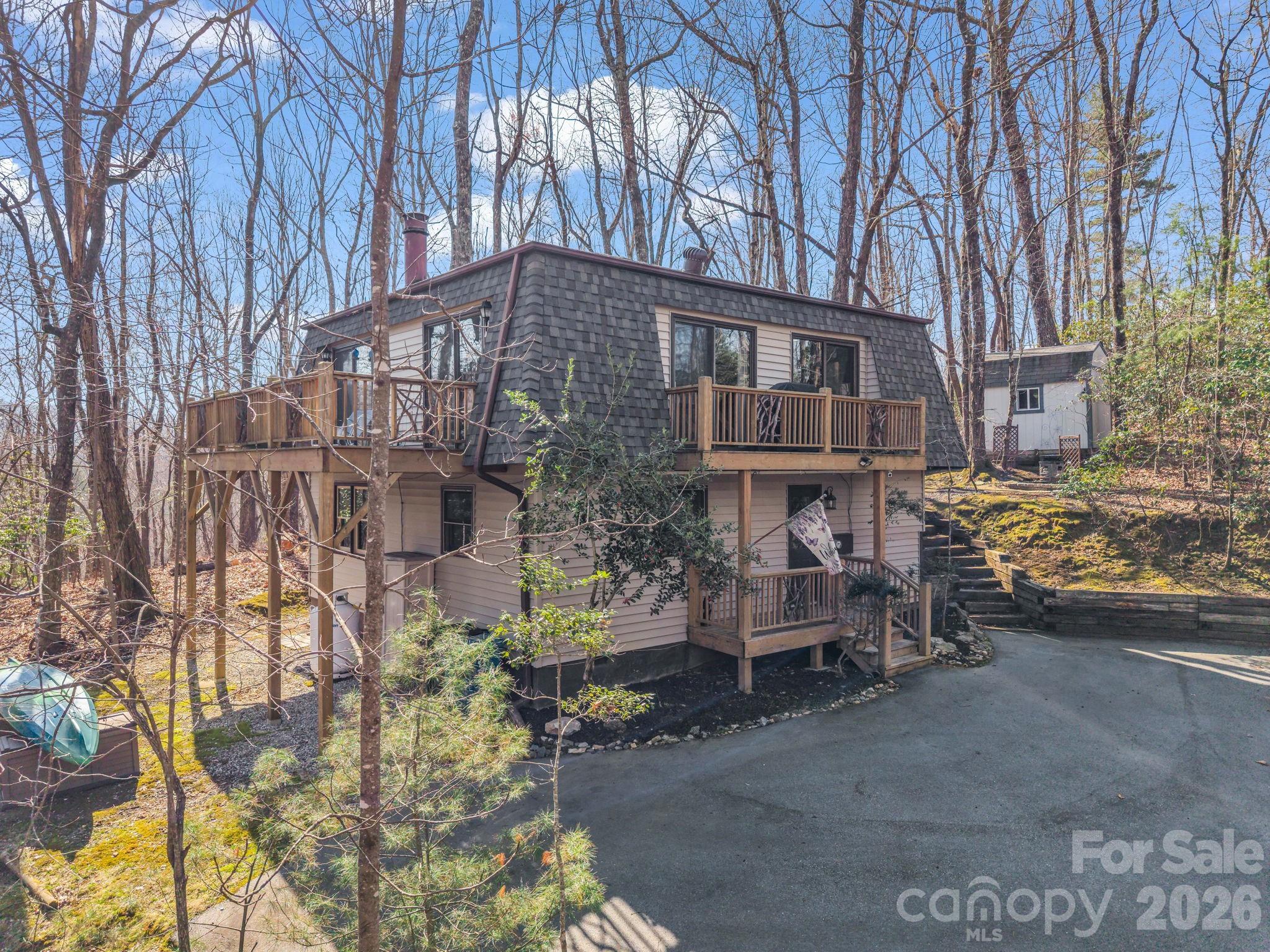 Location! Location! Discover the potential of this unique and updated home in Connestee Falls—a golden opportunity awaits! This 3-bedroom, 2.5-bath Mid-Century Modern gem is priced to sell, offering incredible potential for renovators, DIY lovers, or investors looking to create a masterpiece. Tucked up in the trees on a bluff overlooking lake Ticoa, this private retreat is a nature lovers paradise! Not just a desirable location, this property features a beautiful stone fireplace in the heart of the home. The updated kitchen has all the high end finishes you can expect: granite countertops and backsplash and stainless steel appliances. The expansive windows provide plenty of natural light. Don't be surprised if you see a friendly neighborhood deer looking in! The outdoor decks provide ample space to entertain and enjoy the outdoors. With a new roof, deck, updated bathrooms and kitchen, this home provides the perfect blank canvas to gain instant equity! Hurry and schedule your showing today!