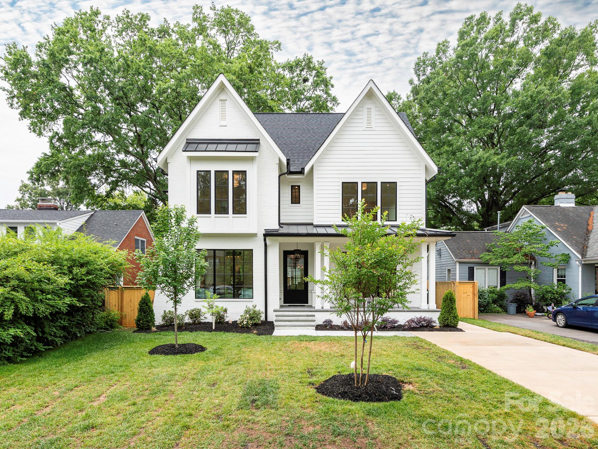 Blending timeless, tasteful design and modern living, this elegant new home in the heart of Chantilly features exceptional attention to detail, elevated finishes, and exquisite craftsmanship throughout. Gorgeous quarter-sawn white oak flooring and 10' ceilings welcome your entry to the functional floorplan, thoughtfully designed for effortlessly graceful living and entertaining. Flooded with natural light, the main level features a spacious foyer, office, guest room/den with en-suite bath and walk-in closet, side-entry drop zone, powder room and generous great room. The beautifully-designed kitchen features top-of-the-line appliances, a large center island, and a walk-in pantry with built-in shelving plus room for a second refrigerator. A cast stone fireplace surround flanked by built-in shelving graces the living area with sliding glass doors opening onto the spacious covered rear porch, complete with built-in gas grill and fireplace. Adjoining the kitchen, the separate dining area offers intimacy and convenience with a wet bar, wine fridge and built-in storage. Alley access leads to the oversized rear-entry garage which is plumbed and hard wired for EV charging on both side walls, and includes a covered front porch leading to the back yard. A large laundry room with utility sink and cabinetry is centrally located on the second floor for ease of access from the primary + 3 abundantly-sized bedrooms, each with en-suite baths and walk-in closets fitted with built-in shelving. The owner's suite is spacious, functional and refined with a tray ceiling and gorgeous, large private bath plus large walk-in closet with custom shelving. Don't miss this rare opportunity to enjoy a brand new home in one of Charlotte's most treasured neighborhoods, convenient to Uptown, Midwood, Elizabeth and beyond!