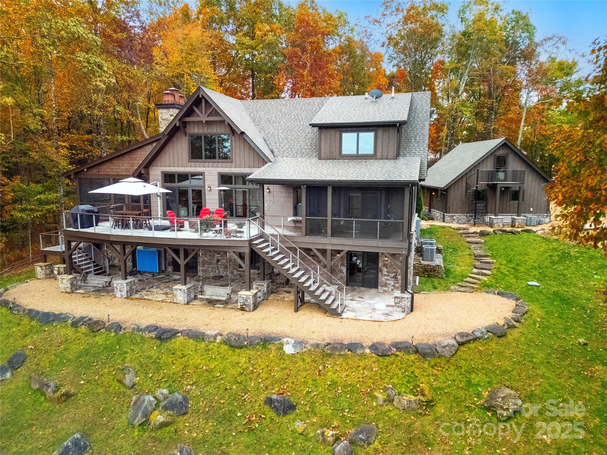 NEW PRICE! SAME GREAT HOME! Set on 6.17 private wooded acres, this exceptional mountain home offers stunning long-range views, quality craftsmanship, and a convenient location in the heart of Western North Carolina. Enjoy easy access to downtown Brevard, Asheville Airport, and Greenville, SC. Built by renowned builder Jerry Brown, this beautifully designed home features 4 bedrooms, 3 stone fireplaces, and warm post-and-beam architecture with hickory floors throughout. Large windows frame breathtaking mountain vistas, including views of Mount Pisgah. The spacious floor plan is ideal for both everyday living and entertaining. Highlights include a custom bar, wine cellar, home theater, fitness room, and multiple outdoor living spaces. Relax on the oversized screened porch with a wood-burning fireplace or enjoy the private screened porch off the primary suite. Additional features include a whole-house generator system, fiber optic internet, radiant heated floors in the primary bath, custom lighting and blinds, and a recently painted exterior. The oversized detached garage includes a studio above, perfect for guests, a home office, or creative space. A Yamaha golf cart is also included.
Thoughtful details throughout—from wood harvested on the property to the fire pit and curated furnishings—create a warm and authentic mountain retreat. Offered fully furnished and move-in ready, this is a rare opportunity to enjoy luxury, privacy, and spectacular mountain living. Check out the video! https://www.youtube.com/watch?v=uAGiVoburHc