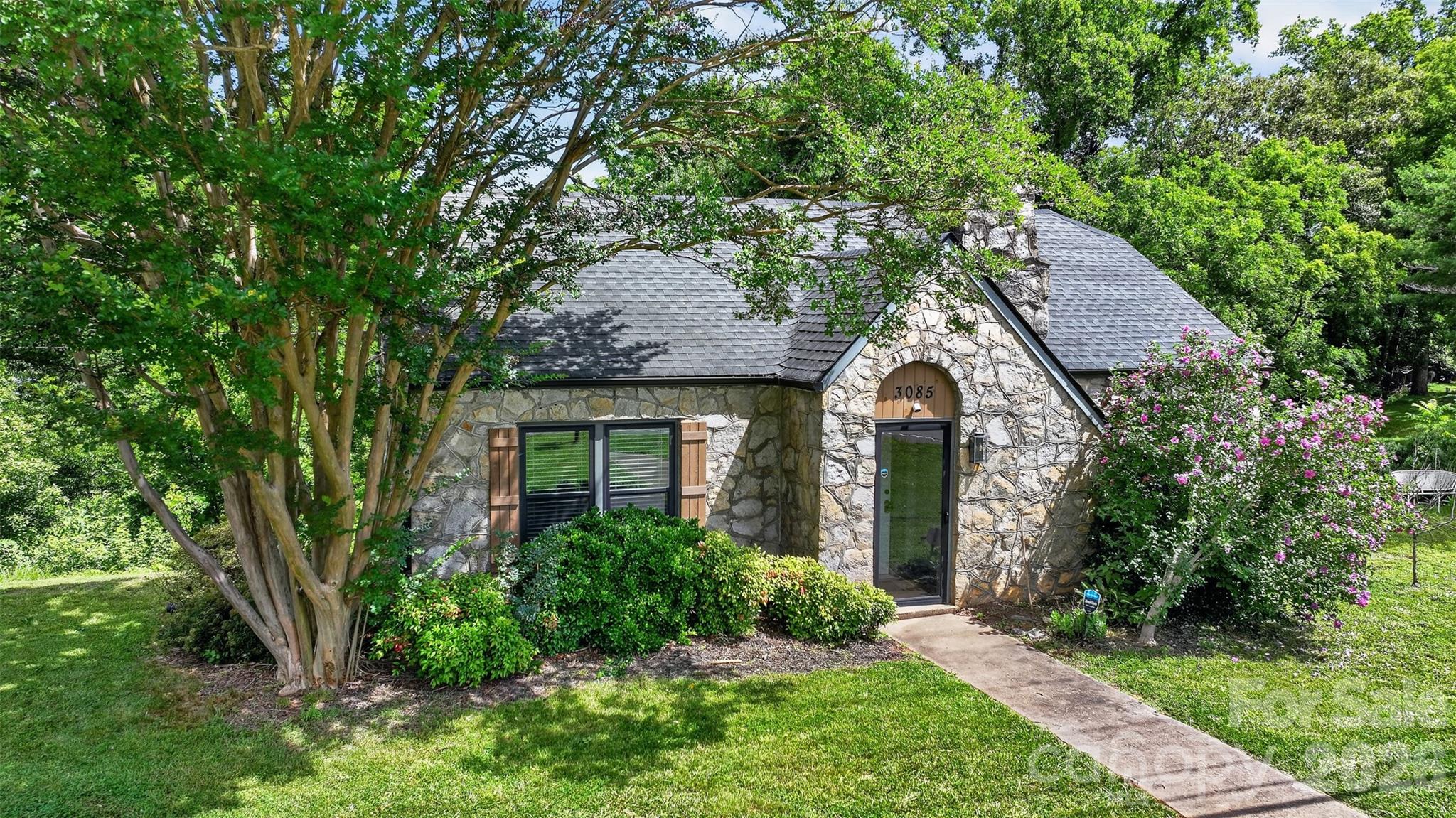 Welcome home to this beautifully remodeled 1945 stone cottage, where timeless character meets modern comfort! Nestled in approximately 1.18 private acres, this move-in ready home offers 1045 ft.² with an exceptional open concept floor plan that feels spacious, bright and inviting. Completely renovated around 2023 the home features refinished hardwood floors, stunning wood ceilings, and a cozy fireplace that serves as a centerpiece of the living area. The beautifully updated kitchen offers crisp white cabinetry, stainless steel appliances, a large pantry and an abundance of work space. Creating a clean fresh look that is perfect for every day living and entertaining. The home includes two comfortable bedrooms and a gorgeous full bath, featuring white tile, a custom solid wood vanity and matching solid wood storage cabinet. Enclosed front foyer provides a warm welcome. Just off the  laundry room, step onto a spacious back deck overlooking a peaceful tree lined backyard that offers exceptional privacy. An ideal setting for morning coffee, outdoor dining or simply enjoying nature. Major improvements include a roof replaced around 2020 and a heating and air system replaced around 2023, providing peace of mind for years to come. The unfinished basement accessible from the exterior offers abundant storage space for tools, lawn equipment or seasonal items. Conveniently located with quick access to I 40 and just minutes from Morganton, Valdese and Drexel and approximately 30 minutes from Hickory. This home offers the perfect combination of privacy and convenience. Whether you're looking to downsize or purchase your first home, enjoy a completely updated cottage with classic charm. This exceptional property is ready to welcome you home.