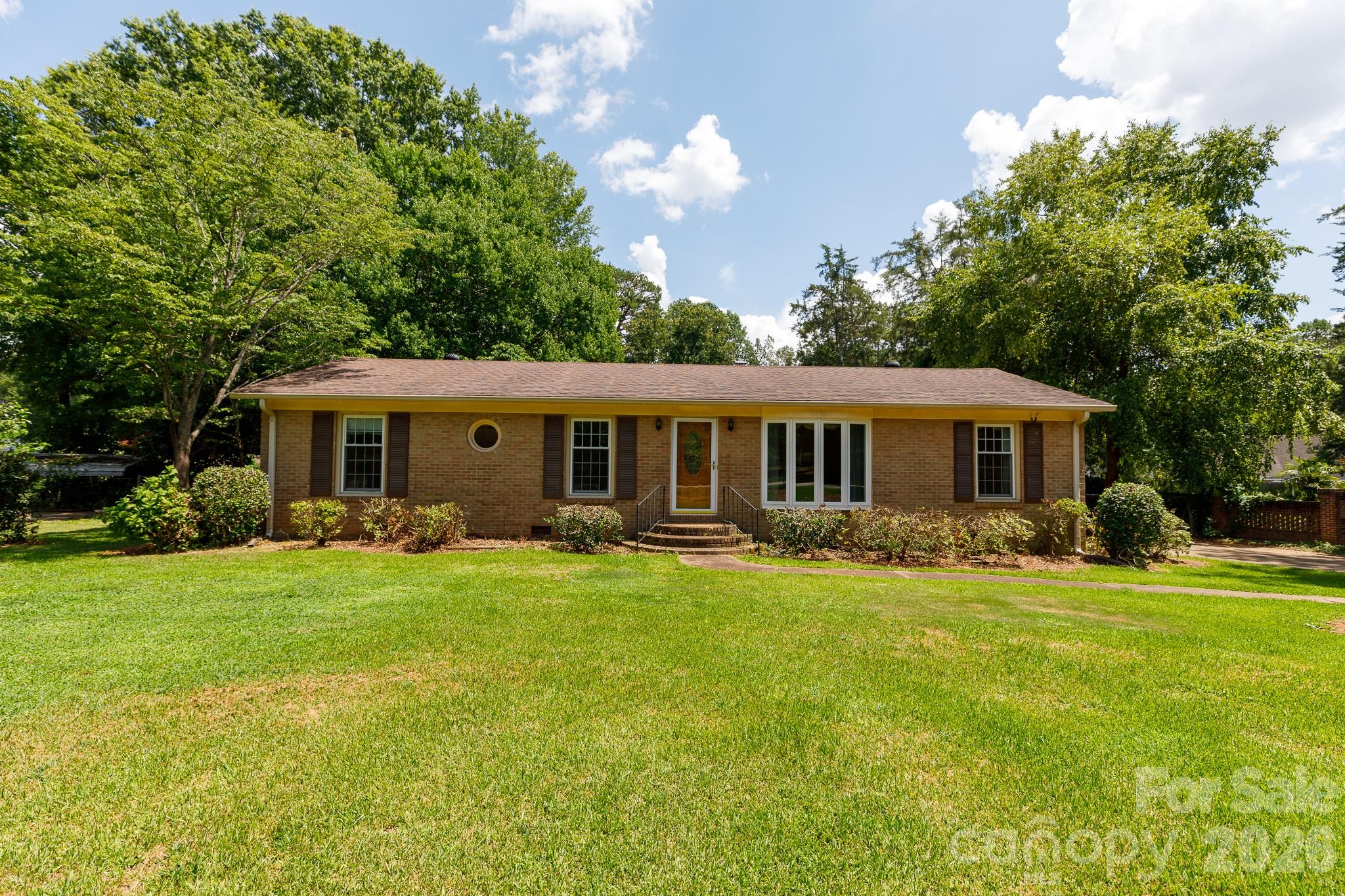 Welcome home to this charming brick ranch situated on a spacious 0.53-acre lot in the established Cato Estates subdivision. This home places you just minutes from local shopping and dining while allowing you to enjoy the benefit of no city taxes. Inside, beautiful hardwood floors run through the main living spaces, leading into a cozy living room complete with a classic fireplace and built-in shelving perfect for displaying your favorite books and decor. The single-level layout features 3 comfortable bedrooms and 2 bathrooms complete with tiled showers. Step outside into the fully fenced backyard to find the ultimate setup for hobbies, projects, or extra storage: a massive 782 square foot detached garage/workshop fully equipped with power. With peace of mind provided by a roof replaced in 2020, this Rock Hill gem is ready for you to move right in and make it your own.