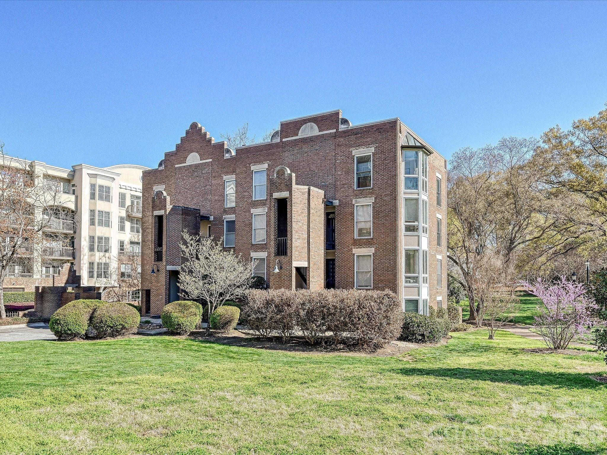 Hidden Gem in Fourth Ward Park! This charming top-level, two-story end-unit condo is nestled in the heart of Fourth Ward with abundant natural light from multiple bay windows. 2 deeded parking spots just steps away from the building. Thoughtfully updated throughout, it features an open floor plan with a renovated kitchen, stainless steel appliances, hardwood floors, exposed beam ceilings, custom built-in storage throughout, and a cozy fireplace. The primary suite includes a large bath with a soaking tub and separate shower. Enjoy a private balcony overlooking the park, two parking spaces, and low monthly dues. Refrigerator, washer, and dryer are included. Low HOA dues. All of this just steps from restaurants, grocery stores, shops, and sports venues—experience the best of uptown Charlotte living!