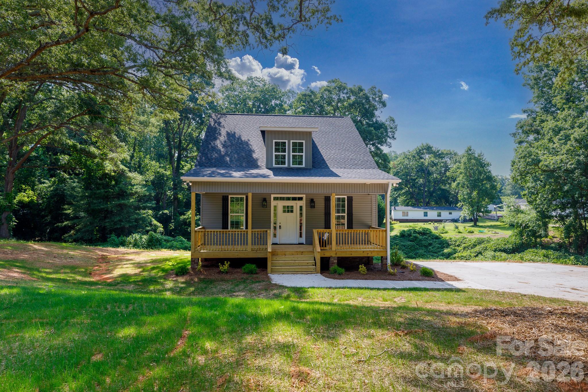 Welcome home to this beautiful new construction situated on a spacious 0.9-acre lot with the added benefit of no city taxes. From the moment you arrive, the large front porch invites you to sit back, relax, and take in the quiet surroundings. Inside, the bright and open floor plan flows seamlessly across durable luxury vinyl plank flooring throughout the main level, creating an ideal layout for both everyday living and easy entertaining. The heart of the home is a stunning kitchen equipped with quartz countertops, a functional center island, a breakfast bar, and a dedicated pantry, all opening directly to the dining area. Retreat to the main-level primary suite, a private oasis featuring a generous walk-in closet, dual vanities, and a beautifully tiled shower. Step outside to the rear covered deck to enjoy peaceful morning coffee or weekend cookouts overlooking your backyard. Offering four bedrooms and two and a half baths, it is a space designed to effortlessly accommodate both busy mornings and quiet, relaxing weekends.