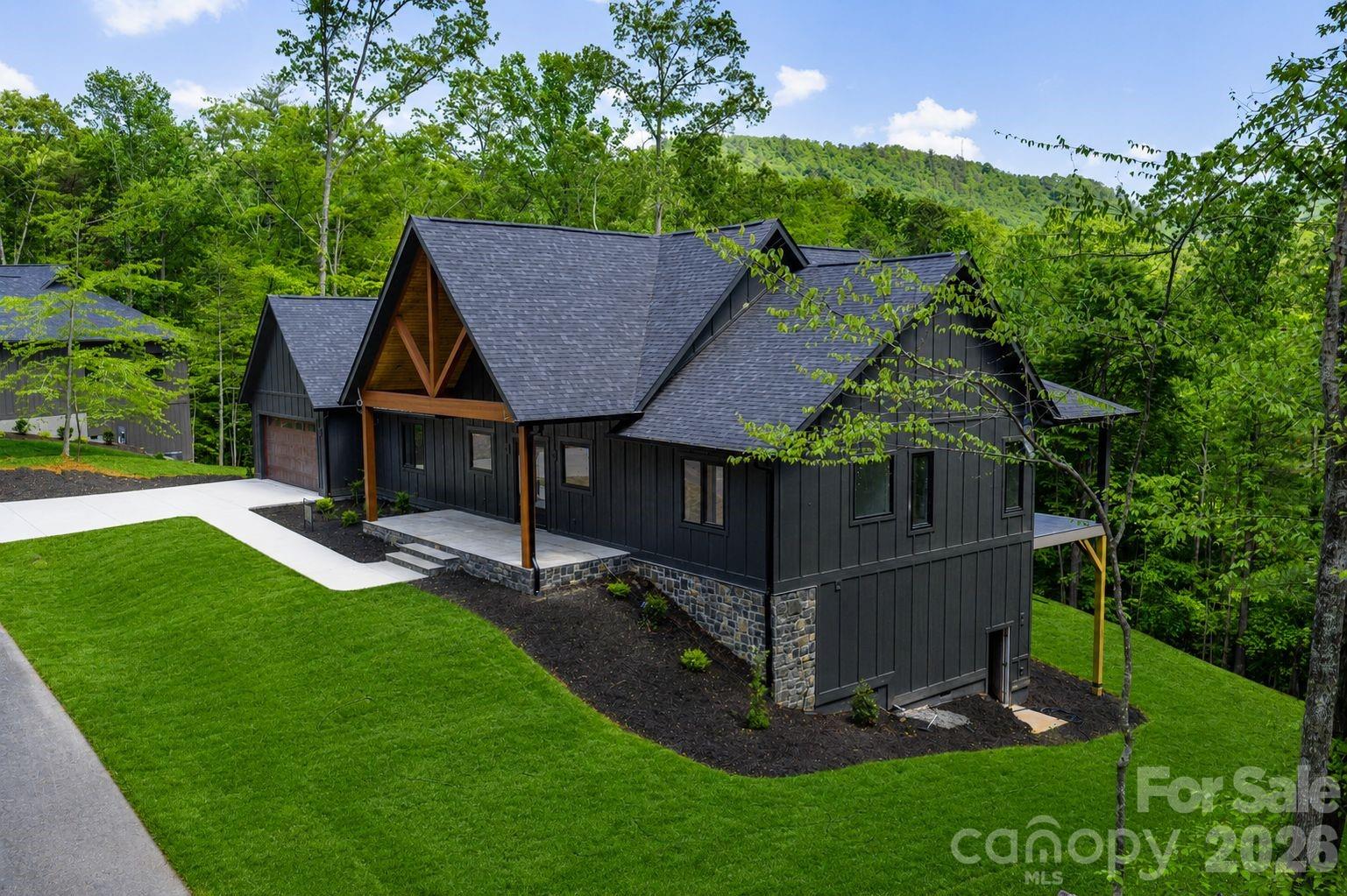 148 Reserve Way is a thoughtfully designed luxury mountain retreat located within the newly established 1901 Reserve community. Perfectly positioned in Etowah, the home offers exceptional convenience with grocery stores, restaurants, medical offices, golf courses, and everyday essentials just five minutes away. Outdoor destinations including Pisgah National Forest and DuPont State Recreational Forest are both within 15 minutes, while Brevard, Hendersonville, and Asheville Regional Airport are all nearby, placing the home in one of the most connected locations in Western North Carolina.

Surrounded by mature trees, the setting feels private and established, with a spacious backyard offering excellent southern exposure and beautiful winter mountain views. The rear of the home was intentionally designed to embrace the landscape, creating a seamless connection between indoor and outdoor living spaces.

This luxury three-bedroom, three-and-a-half-bath home stands apart from anything else currently available in the area. Every detail reflects an emphasis on quality and craftsmanship, including Venetian plaster fireplace, commercial-grade laminate flooring imported from Switzerland, quartzite countertops sourced from Brazil, and European-imported exterior doors and windows — finishes rarely found in this market.

Inside, the home immediately impresses with 20-foot vaulted ceilings in the main living area, complemented by 10-foot ceilings throughout the remainder of the home. Solid-core eight-foot interior doors, custom-designed closets, and private en-suite bathrooms for each bedroom further showcase the thoughtful design. Additional features include a spacious walk-in laundry room and an oversized two-car garage with an 18-foot-wide garage door and approximately 34 feet of depth, offering plenty of room for vehicles, storage, or a workshop.

Built for both comfort and efficiency, the home features 2x6 exterior wall construction with spray foam insulation. One of the home’s defining spaces is the expansive rear deck, which spans nearly the full width of the house and includes Trex decking, black aluminum railings, and a floor-to-ceiling stone see-through fireplace. A private access door from the primary suite creates an ideal setting for quiet mornings or evenings overlooking the mountains.

Words alone do not fully capture the quality, setting, and craftsmanship found throughout this exceptional home. Contact the listing agent today to learn more about this remarkable luxury mountain retreat and schedule your private tour.