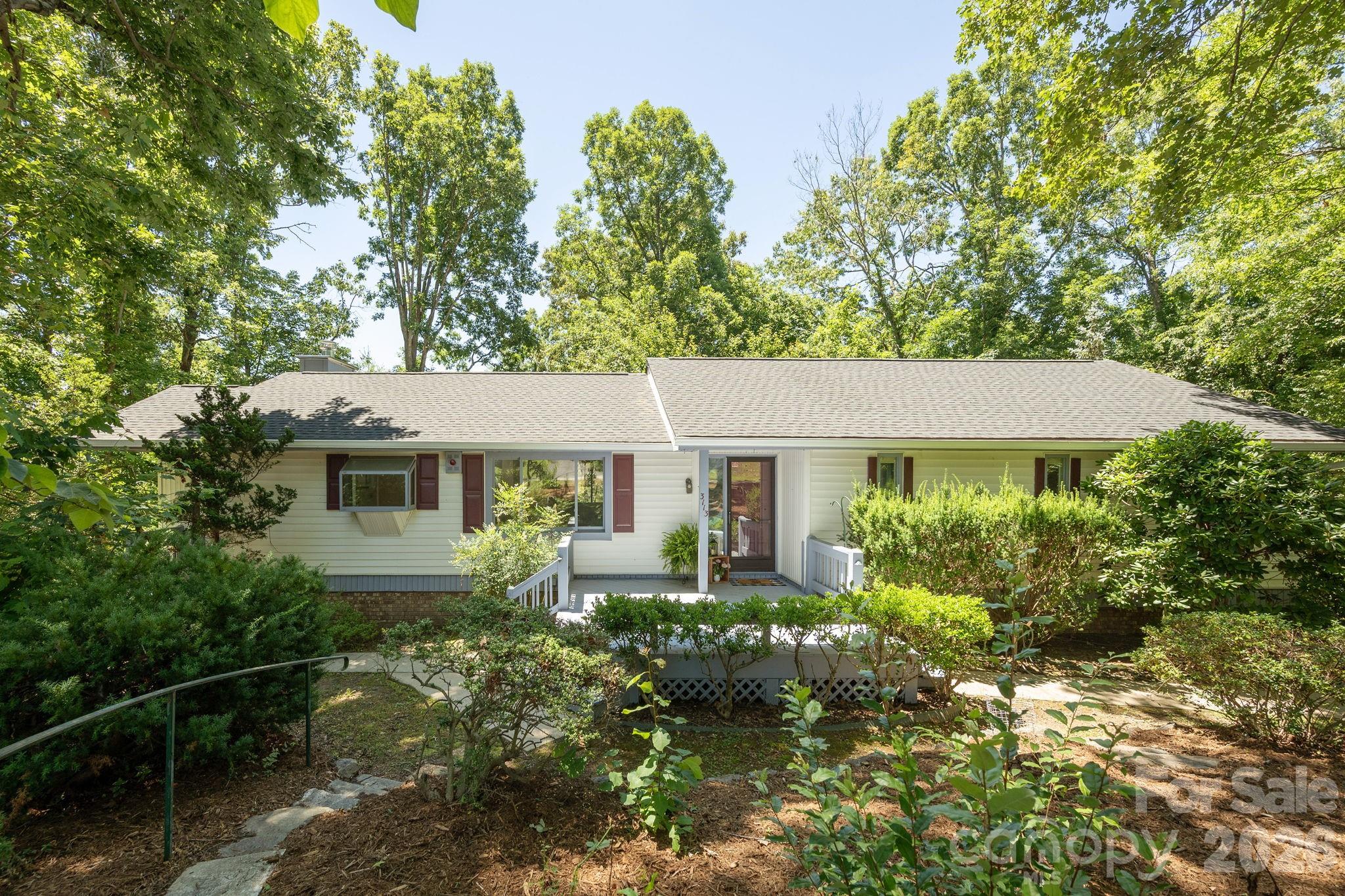 Situated on a lovely wooded lot in the Grimesdale community, this property has so much to offer! With 4 bedrooms, 3 full bathrooms, main floor laundry, 4 seasons room and two fireplaces this home provides plenty of space for everyone! This home has a new roof, all new luxury vinyl plank flooring, interior paint, kitchen countertops and cabinetry; this house is ready for its new occupants! The basement level family room with fireplace, bedroom, bathroom and wet bar area with new countertop could serve many purposes, with its lower level entrance. The oversized garage provides workshop space, along with a dedicated storage area for yard equipment and an attached greenhouse area for all you folks with a green thumb! The heated 4 seasons room on the main level is not counted in the overall square footage but provides year round space for enjoying the tree house effect right outside your den. The location is minutes to downtown Hendersonville, grocery, shopping, restaurants, healthcare facilities and only a short hop to interstate travel, Asheville Airport and south Buncombe County. The generous sized driveway and garage provides plenty of space for your vehicles or hobbies! Come take a look at this fantastic property today! The current 0.86 acre parcel will be divided at closing, leaving 0.44 acres with the home. Buyer will be given first right of refusal for the remaining 0.42 acres.