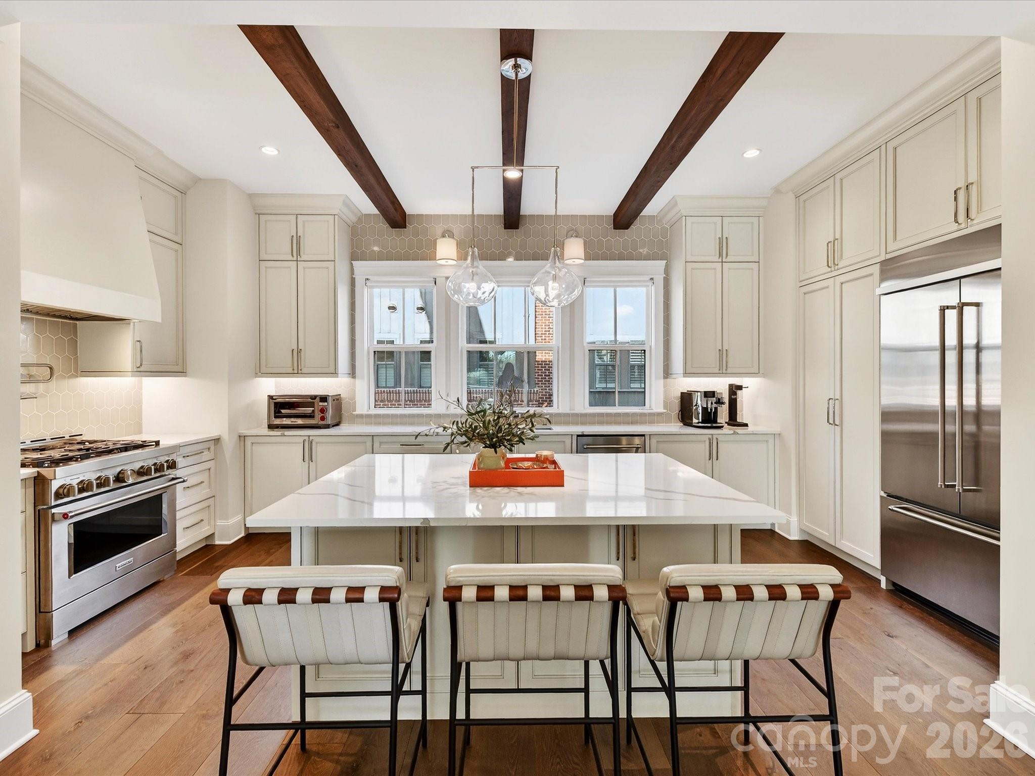 This exceptional end-unit townhome in the heart of Myers Park delivers turnkey luxury, with a two-car side-by-side garage and a charming fenced front yard. The entertainer's kitchen sets the tone: custom cabinetry, a 36" gas range, built-in refrigerator, and an island that anchors every gathering. Step out to the covered front balcony for your morning coffee. 
Three ensuite bedrooms mean everyone has their own space, including a private entry-level guest suite, perfect for visiting family or long-term guests. The primary suite is a genuine retreat with coffered ceiling and bath with double vanity & spa-style walk-in shower. On the top floor, a flexible room with built-in bar, ice maker, refrigerator drawers, and half bath opens directly to the rooftop deck - a space that works as a home office today and a guest suite, gym, or creative studio tomorrow.
Morning walks on Little Sugar Creek Greenway, dinner on Selwyn and shopping at Park Road Shopping Center within steps of your front door, and a rooftop deck made for the life you've earned.  This is exactly where you belong!