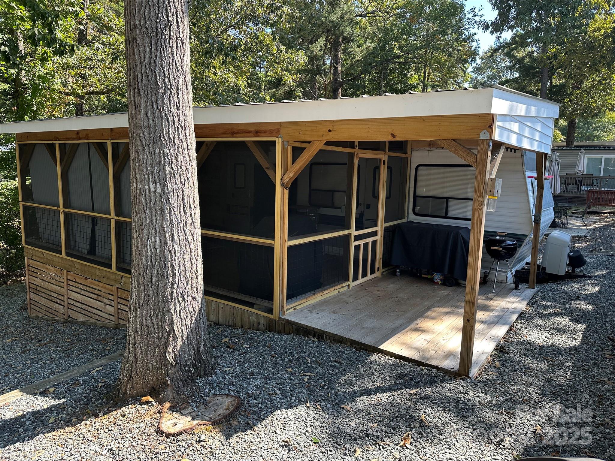 This beautifully remodeled 1-bedroom camper with a fantastic screened porch is ready for you to enjoy. The spacious, shaded lot has been fully graveled, making it nearly maintenance-free — no more spending weekends mowing! The large porch offers both an open grilling area and a screened section perfect for relaxing and watching TV after a day on the water. Inside, the camper features updated flooring, a convenient sleeper sofa for extra guests, and an energy-efficient mini split for heating and cooling. The rubber roof has been replaced for peace of mind. A storage building is included, giving you space for beach chairs, rafts, and lake toys. Located inside the gated, waterfront community of Badin Shores Resort, you’ll enjoy resort-style amenities including a swimming pool, putt-putt golf, basketball and pickleball courts, picnic pavilions, playgrounds, fishing pier, sandy beach and swim area, waterfront boardwalk, clubhouse, and more. Lake Life starts here – come see it today!