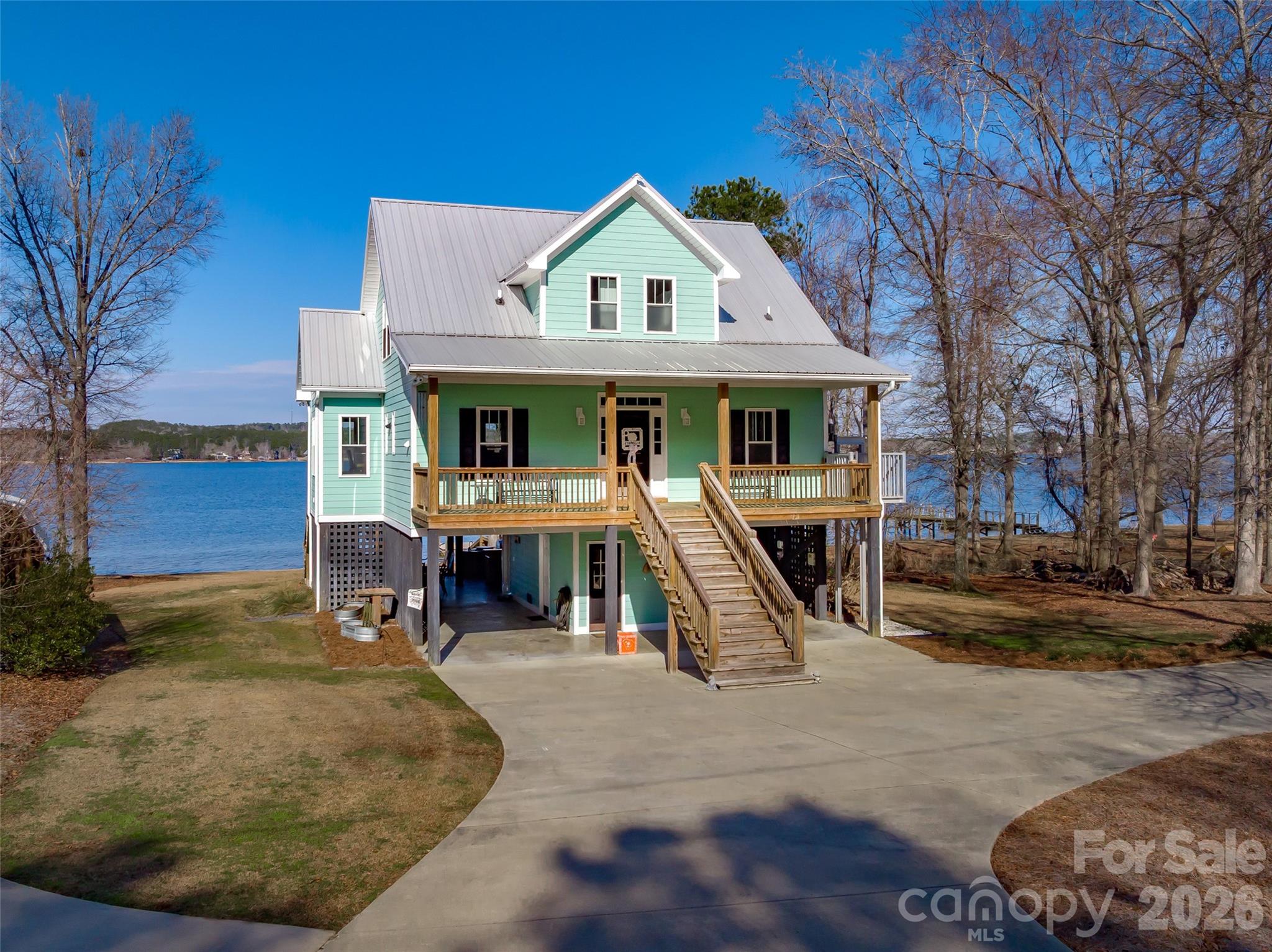 Where's the party at? If you want to be the place to be this summer, look no further. This home was set up with hosting and entertaining in mind! Stunning main channel views from every room of this beautiful home built in 2015. Gorgeous hardwood floors, ceramic tile and granite throughout, a walk in tile steam shower and his and hers closets in the primary on the main level and a smart second living area with guest rooms upstairs. But the thing that you'll love most other than the fantastic lake views is the party pad underneath. Constructed with stone and granite and stainless steel appliances, this bar and full kitchen with seating and mounted TV's all around is calling your name this summer! There is a 3rd full bath down here also and a convenient storage area for the lake toys. Relax on the firepit deck or take a short, easy walk down to the dock. Need a place for swimmers? This one has that too! And did I mention it has a convenient lift from the parking area up to the main floor? Yep. They thought of everything. Literally the perfect lake house for weekends or full timers!