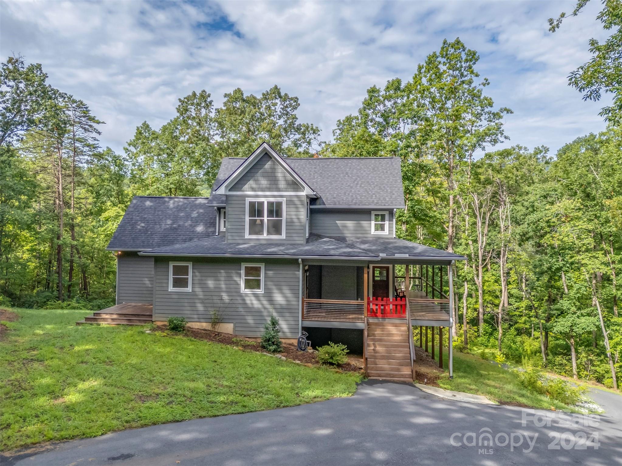 Nestled on a 2-acre lot in the coveted Gillette Woods community, this 3-bedroom, 2.5-bath home exudes modern charm and privacy.  Built in 2021, the home boasts a seamless open floor plan, ideal for everyday living and entertaining. The well-appointed kitchen features wood cabinets with soft-close doors, stainless steel appliances, a farm sink, and a functional island/breakfast bar.  The main level includes the primary bedroom, ensuite bath, walk-in closet, and a separate laundry room. Upstairs, two additional bedrooms and a full bath provide ample accommodations. Other highlights include dual heating/cooling zones, a cozy gas log fireplace, 9-ft ceilings and ceiling fans throughout. Outside, a covered wrap-around porch invites relaxation amidst the serene woodland surroundings. Completing this exceptional property is a full unfinished basement offering storage galore and potential for future expansion. Enjoy the best of peaceful mountain living just 1.5 miles from downtown Tryon.
