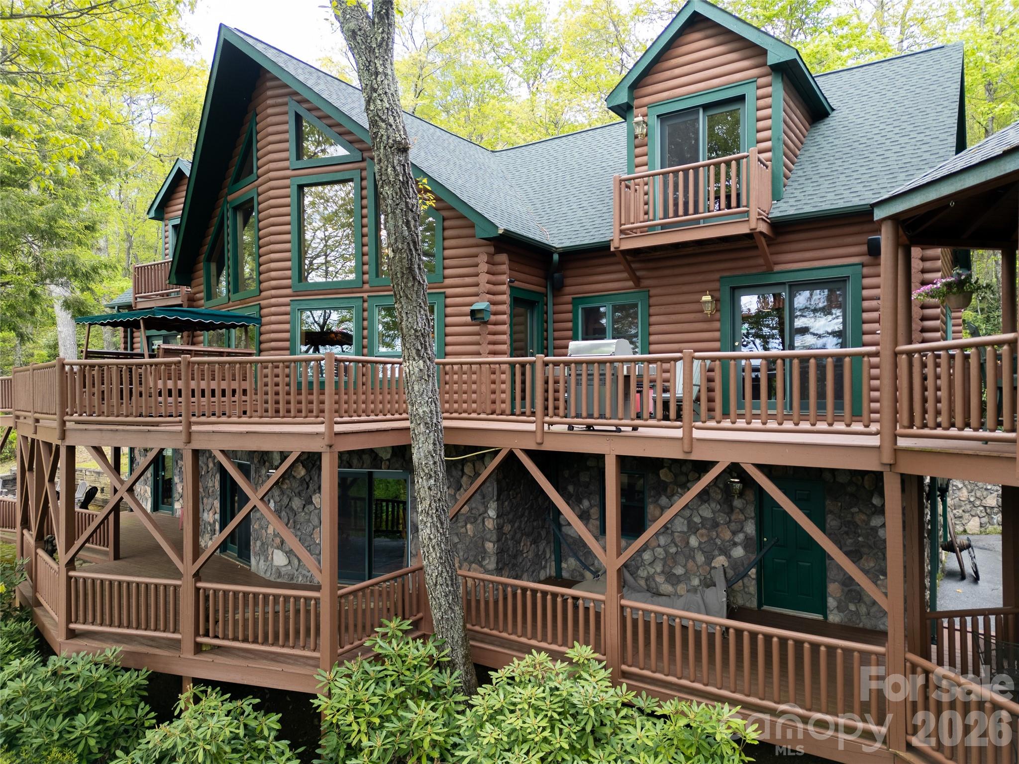 Inspired by the spirit of Breckenridge ski lodges and designed for gathering, Falcon Crest Lodge is a private mountain retreat where weekends become traditions and memories are made for generations. Set at an awe-inspiring 4200’ elevation on over 3 acres, this gated estate captures sweeping long-range views from Maggie Valley’s valley floor to its surrounding mountain ridges. 

Crafted by respected local builders, the home blends authentic lodge architecture with exceptional craftsmanship and spaces designed to bring people together. The soaring two-story great room features a dramatic wall of windows, massive stone fireplace, vaulted tongue-and-groove ceilings, Hickory floors, and custom antler chandeliers sourced from Montana. 

The expansive floorplan was created for entertaining on every level. Multiple gathering spaces include a chef’s kitchen with custom Hickory cabinetry, large dining areas, expansive covered decks, a lower-level game and billiards lounge with custom bar and fireplace, outdoor firepit area, gazebo, and numerous spaces to relax after a day of adventure in the mountains. 

The main-level primary suite offers a private fireside retreat with deck access, while upper guest bedrooms each enjoy their own mountain character and balcony access. Bonus and flex rooms on the lower level provide additional sleeping, office, recreation, or retreat possibilities.

Outside, the experience continues with gated access, ample parking, detached workshop/studio space, separate playhouse, newly stained and sealed exterior, and new roof in 2024.  The detached workshop is a standout feature with electricity, wood stove, and exceptional versatility as a hobby space, game room, studio, gathering space, or creative retreat. The separate playhouse/studio also offers electricity and charming additional flex space tucked just below the home.

Whether envisioned as a luxury mountain getaway, unforgettable vacation rental lodge, corporate retreat, or legacy gathering place for family and friends, Falcon Crest offers a rare opportunity to own a true Blue Ridge destination property just minutes from the heart of Maggie Valley.