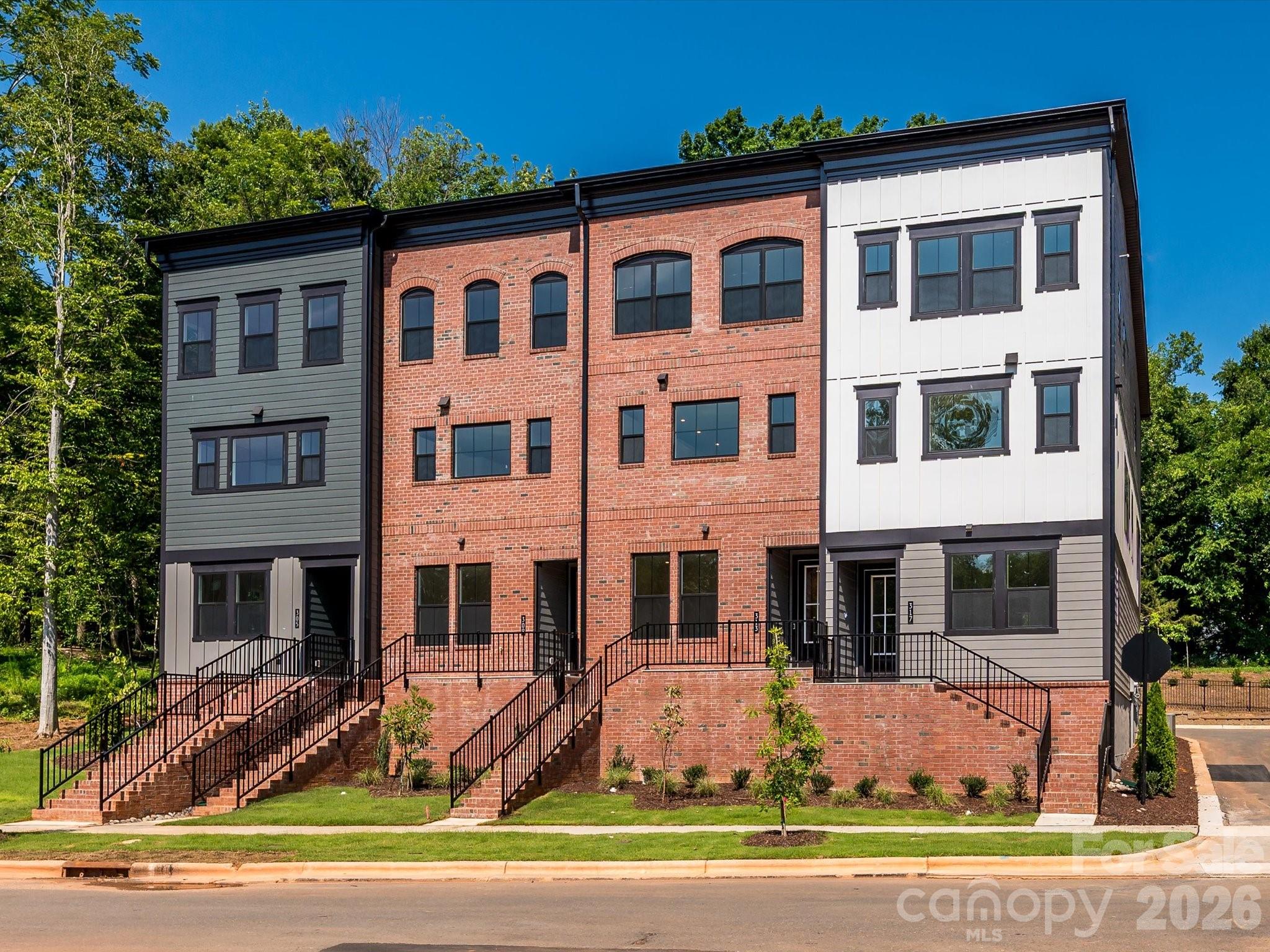 Welcome to 317 Old Town Village, a Price plan townhome tucked away in the charming, tree-lined community of Old Town Village in Waxhaw, NC. This stunning end-unit offers added windows throughout, flooding the home with natural light across all three levels. On the first floor, a fourth bedroom with a full bathroom features beautifully tiled walls in the walk-in shower, ideal for guests or multigenerational living. Oak box stairs with open rails carry through both the first and second floors, adding an elevated, airy feel. The second floor showcases a gourmet kitchen outfitted with white cabinets, white quartz countertops, a GE 36" gas cooktop, a large single bowl stainless steel sink with a Delta Essa Touch faucet, and a striking grey Mythology-Harmonia picket mosaic backsplash, all flowing seamlessly to a covered outdoor living space. The Convenience Package adds thoughtful touches like double roll trays and base waste basket for effortless daily organization in the kitchen. On the third floor, the primary en suite impresses with rich grey cabinets, white quartz countertops, and a beautifully tiled walk-in shower. A 2-bay tandem garage rounds out this exceptional home. With access to historic downtown Waxhaw's local shops and dining, 317 Old Town Village offers the perfect balance of privacy, charm, and modern living. Schedule your tour today.