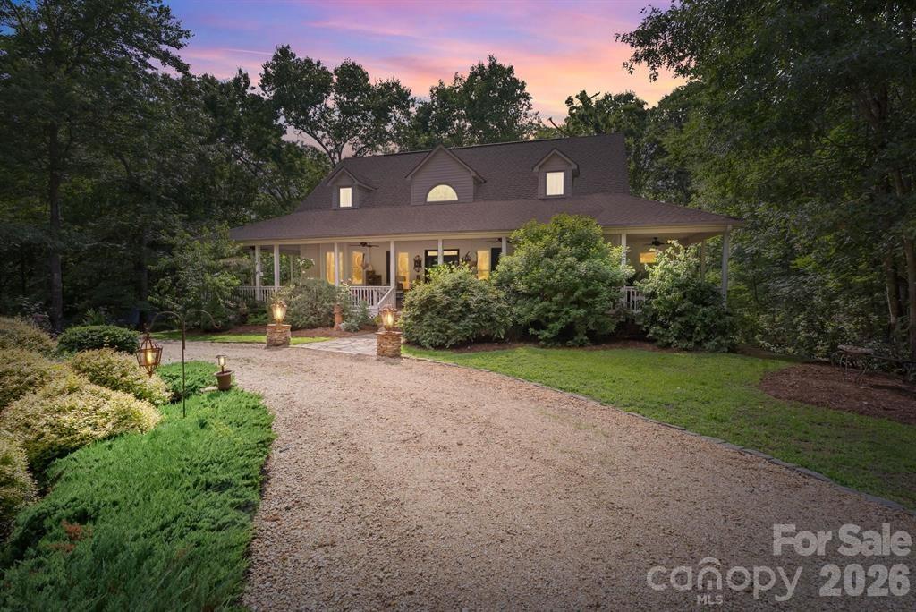 Hidden among the privacy of lush hardwoods in coveted Lake Adger, 175 Green Hills Road is a breathtaking mountain retreat. Encompassing more than 14 wooded acres, this exceptional property invites exploration with over one mile of private trails winding through the natural landscape. A scenic gated drive meanders through the woods before revealing the home's welcoming exterior and beautifully appointed wraparound porch, perfectly positioned to showcase the picturesque surroundings. The grounds are equally impressive, featuring thoughtfully designed gardens and a serene koi pond accented by two soothing waterfalls, creating a setting of extraordinary peace and natural beauty. Inside, abundant windows and transoms fill the home with natural light. The stunning great room centers around a floor-to-ceiling stone fireplace with a handcrafted mantel, creating a warm yet sophisticated focal point. The open-concept floor plan flows seamlessly into the dining area and screened porch, providing effortless indoor-outdoor living. The chef's kitchen is both beautiful and functional, featuring a Wolf gas cooktop on the island with bar seating, Bosch wall oven and convection steam oven, custom cabinetry, farmhouse sink, and a charming window seat that quickly becomes everyone's favorite place to relax. The spacious main-level primary suite offers a spa-inspired bath complete with an iron clawfoot soaking tub, tile shower, dual vanities, designer lighting, and bidet. Two customized walk-in closets and a conveniently connected laundry room with built-in cabinetry and shelving enhance the suite's thoughtful design. An adjoining office with exposed wood beams and a wall of windows provides an inspiring workspace immersed in nature. A stylish powder room completes the main level. Upstairs, two generously sized guest bedrooms feature a split-bedroom layout, each offering space for sitting areas or reading nooks. A full bath serves the upper level. The expansive lower level provides exceptional flexibility with a large recreation and living area featuring a fireplace and access to the covered flagstone patio. Additional spaces include a fitness room, second office, art studio, 10' x 23' workshop, and two oversized storage rooms. In addition to the heated square footage, the lower level also offers substantial finished, unheated living space that includes a studio with kitchenette, bedroom, full bathroom, office, and additional flexible-use space—ideal for guests, hobbies, multigenerational living, or a private retreat. Outside, a pergola with a cozy firepit creates the perfect gathering space beneath the stars, making this property equally suited for relaxation and recreation. Ideally located just minutes from Tryon International Equestrian Center and within easy reach of Asheville, Greenville, Saluda, local vineyards, and the Blue Ridge Mountains, this private haven feels worlds away while remaining conveniently close to the region's finest destinations. A rare opportunity to own an extraordinary home where luxury, nature, privacy, and timeless craftsmanship come together in perfect harmony.