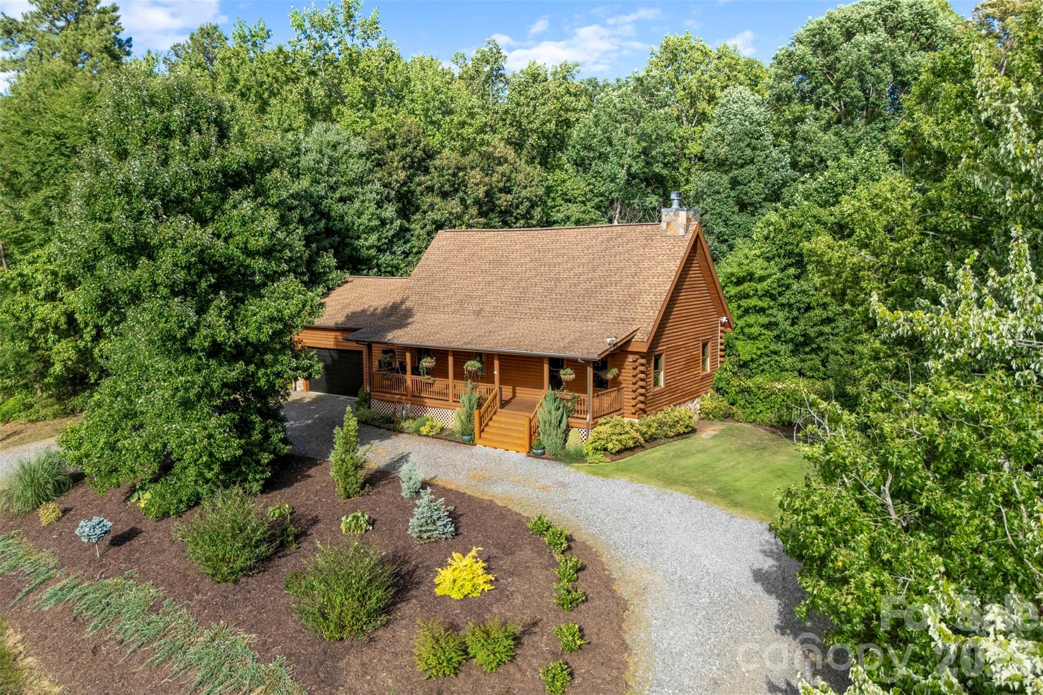 Welcome to your own private Lake Norman retreat, where lake living, privacy, and character come together in a way that's getting harder and harder to find. Situated on approximately 1.4 acres with lake views from your rocking chair front porch, this custom log home feels like a mountain getaway, yet you're just .4 miles from Stumpy Creek Park and public boat launch. Imagine spending your mornings on the lake, afternoons exploring the park, and evenings gathered around the fire pit under the Carolina sky. 
Pull into the driveway and you'll immediately notice the privacy, mature landscaping, and inviting front porch that makes you want to sit down and stay awhile. Inside, soaring cathedral ceilings, exposed beams, warm hardwood floors, and a stunning stone fireplace create the cozy, welcoming feel that makes a log cabin so special. The open floor plan is perfect for entertaining or simply enjoying everyday life, while the beautifully updated kitchen features granite countertops, Samsung Bespoke white glass appliances, an oversized island, and custom open shelving.
The current owners have poured so much into this home, with thoughtful updates throughout that blend style with function. You'll find designer lighting, updated cabinet and door hardware, custom closet systems in both the primary suite and main level bedroom, matching hardwood flooring added to the main level bedroom, custom shelving in the kitchen and main floor bath, a Tesla charger in the garage, plus smart home features including Nest security cameras and Yale smart locks on the front, garage, and basement entrances.
The walkout basement has been completely transformed into an incredible entertaining space with luxury vinyl plank flooring, a custom coffered ceiling, accent lighting, and a handcrafted bar with custom shelving. Whether you're hosting football Saturdays, backyard cookouts, or winding down after a day on Lake Norman, this is the space everyone will naturally gather.
Step outside and you'll find even more to love. The backyard has been enhanced with immaculate landscaping, raised garden beds, additional landscape beds along the fence line, a spacious patio, fire pit, aluminum-fenced yard, & new sod. Other improvements include updated back deck boards with aluminum railings, new front porch stairs, and a storage shed that's perfect for all of your lake gear and outdoor equipment.
The major systems have already been taken care of too, including a new well pump and expansion tank installed in Fall 2025, along with septic servicing and replacement components completed in April 2026, giving the next owners added peace of mind.
With no HOA, room to store your boat, and one of Mooresville's most desirable locations near Lake Norman, this home offers the best of both worlds. You're only minutes from shopping, restaurants, and everyday conveniences, but every time you come home, it feels like you've escaped from it all.
Homes like this don't come along often. If you've been looking for a property that offers privacy, character, room to breathe, and an authentic Lake Norman lifestyle, 133 Folkstone Road is one you simply have to experience.