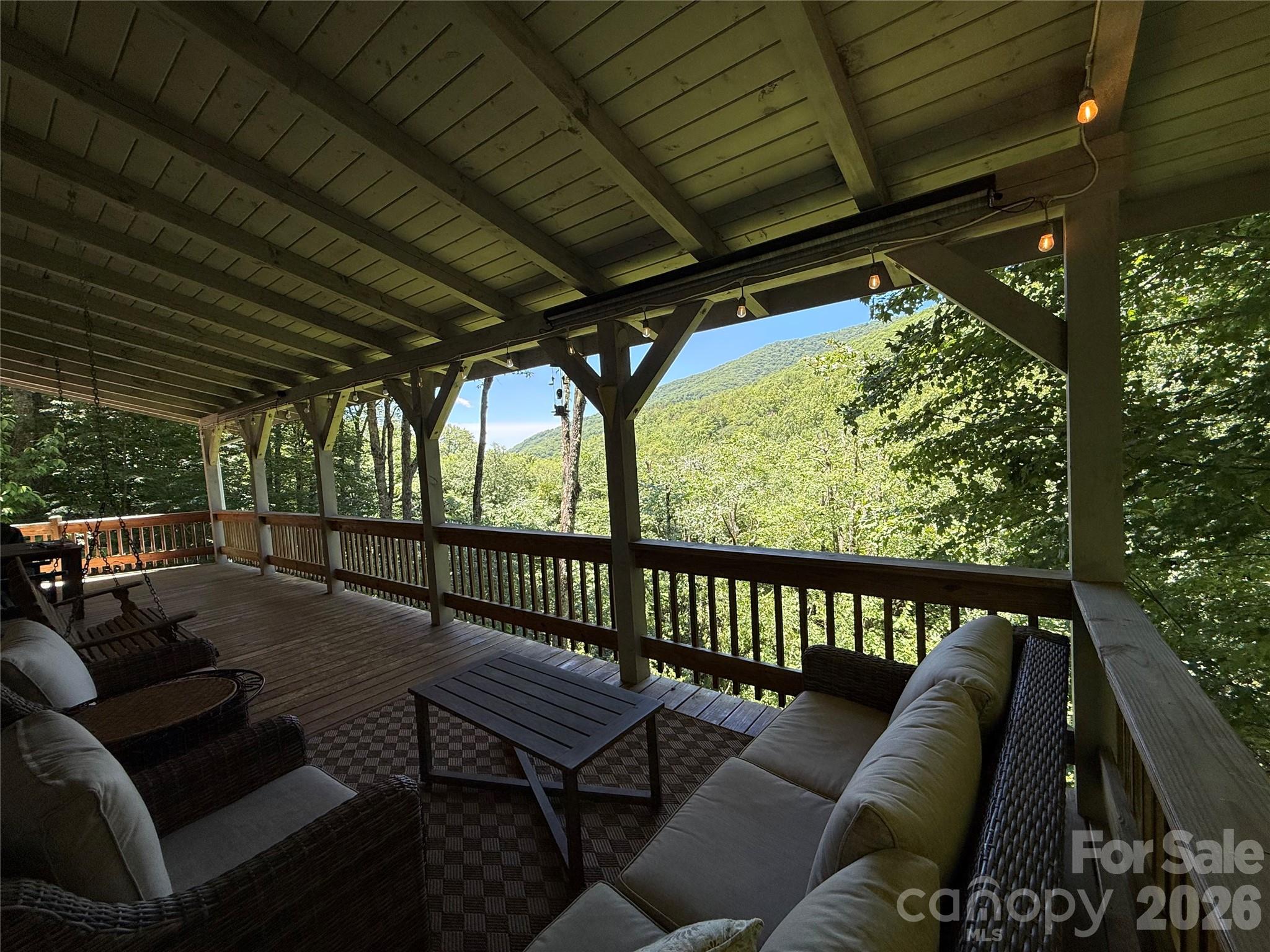 Perched perfectly on a private, 1.92-acre homesite, this custom, artisan-built log cabin offers a rare trifecta of mountain seclusion, high-speed connectivity, and effortless year-round recreation. Located just five minutes from the slopes of Cataloochee Ski Area, this original-owner gem sits in one of the closest residential communities to the resort, making it the quintessential Maggie Valley ski cabin. Lovingly maintained and never before rented, the property is in exceptional condition. Because short-term rentals are permitted here, it stands as an outstanding investment opportunity with beautiful mountain views. Complete with high-speed fiber internet and a highly coveted level parking area that comfortably accommodates four or more vehicles, this estate checks every single box for discerning buyers.

Inside, the thoughtful three-level layout is masterfully designed for modern living, comfort, and ultimate versatility. The main level welcomes you with a bright, sweeping open-concept kitchen, dining, and living area anchored by a stunning, floor-to-ceiling stone fireplace with gas logs. Large windows perfectly frame the surrounding valley views, creating an inviting space to gather, while a serene bedroom and full bath on this floor ensure long-term, accessible comfort. Upstairs, the home expands into a spacious loft—ideal for a home office, game room, or additional sleeping quarters—alongside a private bedroom and full bath. The finished walk-out lower level functions beautifully as a private guest suite or recreation hub, offering a large bonus room, a full bath, and a flexible additional room perfect for a fitness space, media center, or hobby area.

The interior layout harmonizes beautifully with the home’s incredible natural surroundings, inviting the outdoors in at every turn. Step out onto the expansive covered wraparound decking to enjoy quiet mornings and evening gatherings, all while listening to the soothing, rhythmic sounds of nearby Fie Creek. Directly below the main deck, a dedicated, covered space offers the perfect, private footprint for a future hot tub. As the autumn leaves drop, the landscape transforms to unveil dramatic, sweeping winter views of the surrounding mountain peaks, offering an ever-changing backdrop to your mountain lifestyle.

Adventure waits right outside your doorstep, making this an outdoor enthusiast’s absolute paradise. Beyond its unmatched proximity to the ski slopes, this property features highly coveted, deeded daylight access into the historic Cataloochee Ranch trail system, unlocking miles of scenic hiking and breathtaking high-elevation vistas. You are also just moments away from The Swag, one of North Carolina’s premier mountaintop luxury resorts and fine dining destinations. With remarkably low annual HOA dues of just $500, this property is an absolute rarity. Whether you are seeking a permanent residence, a private mountain sanctuary, or a high-performing short-term rental asset, 311 Copper Spur offers an authentic blend of craftsmanship, modern connectivity, easy access, and alpine adventure that is increasingly difficult to find in Western North Carolina.