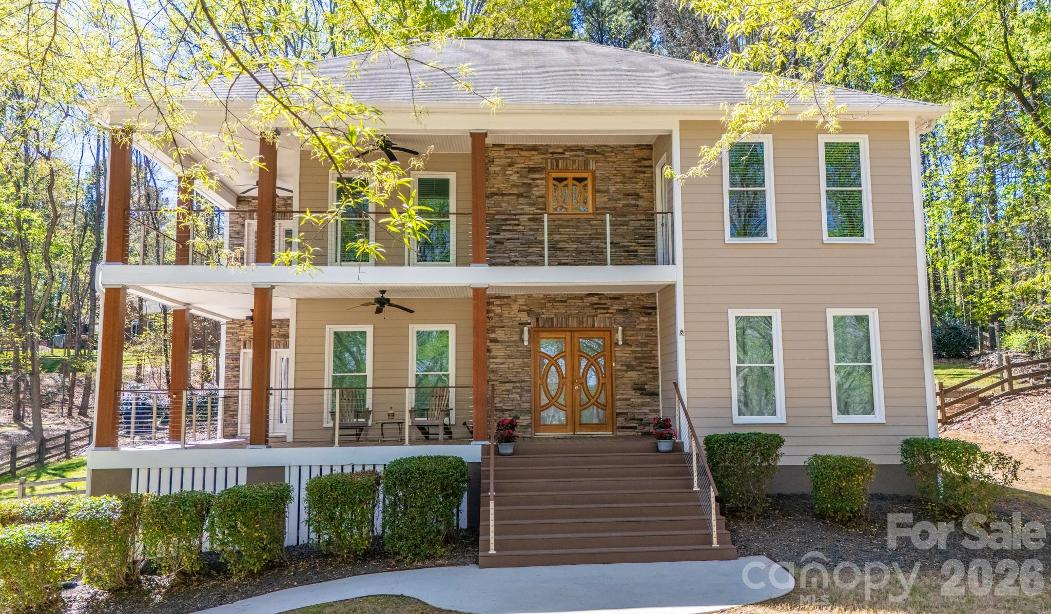 Beautifully updated home on an elevated homesite with gorgeous Lake Norman water views and a DEEDED BOAT SLIP!  Take in nature's tranquility from your choice of two wrap-around front porches while sipping your cup of coffee or a favorite cocktail.  Enter through the custom front doors into a lovely foyer with a dedicated home office on one side and dining room on the other that leads to the newly remodeled kitchen, the true heartbeat of the home!  Kitchen features include a second sink, wine fridge, double ovens, reverse osmosis water faucet from the newly installed water treatment system, gas stove top and solid wood cabinets with soft close drawers and cabinets.  The spacious great room has a gas log fireplace.  Upstairs the primary suite has his & her custom closets w/shelving systems, cork flooring, access to the 2nd story covered porch and newly remodeled ensuite bath.  Laundry room w/separate sink makes cleaning a breeze.  Two other bedrooms w/remodeled jack and jill bath complete the space.  The basement provides a fun recreational space, full bathroom and access into the garage.  Entertain friends & family while grilling out on your back deck or choose to sit around the fire pit.  Community amenities include: pool/pool cabana, paddle board launch site, community beach, picnic area and boat storage.  Assigned to highly rated schools!  Close to shopping, retail, restaurants, & HWY 77.