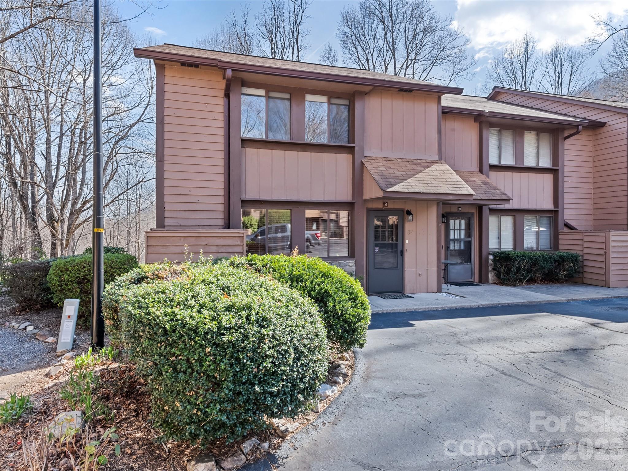 In the fall and winter, this spectacular townhome boasts jaw-dropping 360-degree mountain views, leaving you feeling completely surrounded by nature's seasonal masterpiece. Nestled in the heart of Maggie Valley, this exceptional end-unit townhome offers a bright and airy mountain escape that is perfect for year-round living or a second home.The main level is anchored by a beautiful rock wood-burning fireplace, creating an inviting space for cozy evenings. This level also features a kitchen with freshly refinished cabinets and tile countertops, opening to a dining area and a living room with a unique picture window—the only one of its kind in the neighborhood. A convenient half-bath and a large walk-in storage closet complete the first floor.The upper level serves as a private sanctuary, housing a primary bedroom with a full custom-tiled bath and two comfortable guest bedrooms served by a second tiled full bath. The primary ensuite is a true highlight, opening onto a balcony where you can take in panoramic mountain views and enjoy the comfort of being hugged by nature in the spring and summer months. Located as an end unit, the home provides easy access to the spacious level commons area, offering a quiet sanctuary to enjoy the fresh air and mature landscaping. This impeccably kept townhome is a rare find that perfectly captures the tranquility of Maggie Valley, with the added peace of mind that no rentals are allowed in the community. Update: Step into a home that feels brand new. The main level has been meticulously refreshed with stunning, high-durability luxury vinyl plank flooring throughout. This upgrade follows a professional remediation of a localized plumbing leak, offering the perfect blend of modern aesthetics and total peace of mind for the new owner.