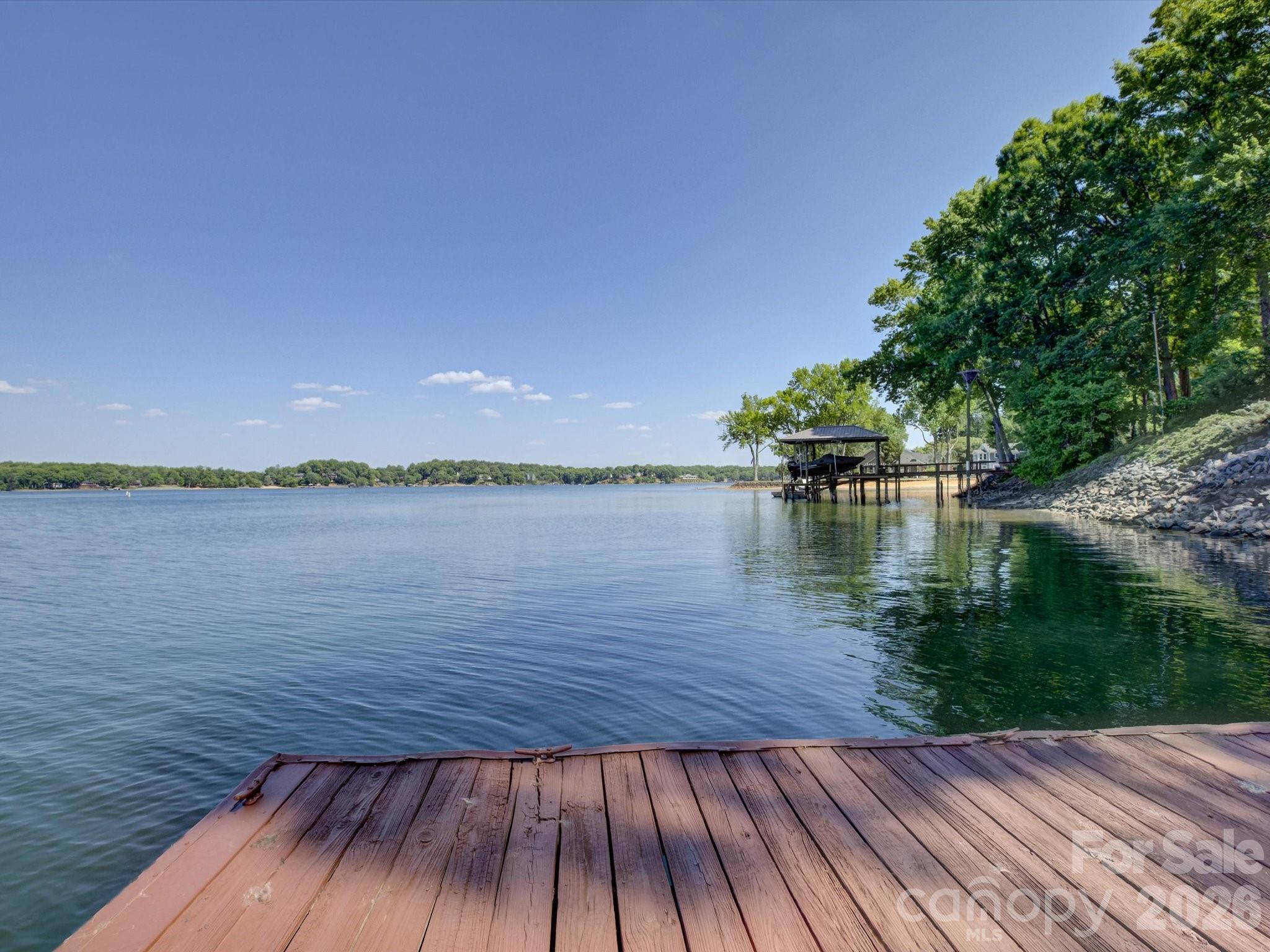 Sought after Lake Wylie living in this wonderful waterfront home with stunning year-round views and direct access to the water! Enjoy the deep water (more important than ever!), a great dock, extended deck, and a boat lift all on a gorgeous lot with loads of privacy! This light and bright home offers effortless, single-story living with fresh interior paint, en trend lighting, and a welcoming layout that takes advantage of beautiful lake views! Bonus features include an updated roof, exterior paint, a pre-inspected septic system, and professional landscaping! Huge primary bedroom with great storage, lovely windows, and access to the covered back porch to enjoy our Carolina weather! The unfinished walkout basement provides incredible storage, awesome potential for expansion, and currently includes a dedicated workshop space with easy access to the backyard. This is a rare opportunity to own lakefront property with immediate enjoyment at a price that allows for room in your budget to customize!