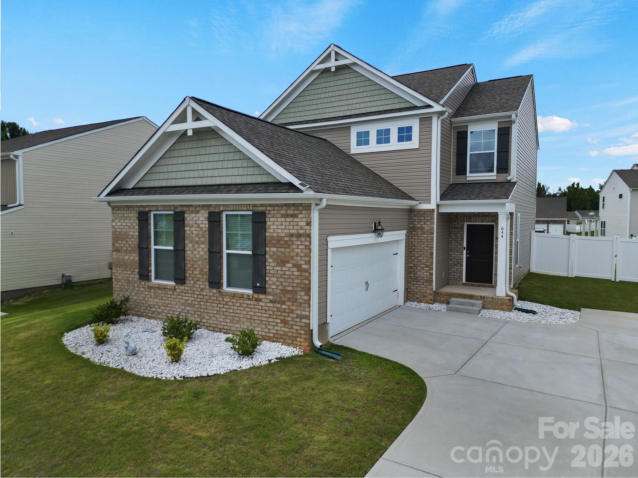 Built in 2023, this 3-bedroom, 2.5-bath home blends modern finishes with a great layout and amazing curb appeal. The open-concept main level brings the living room, kitchen, and dining area together, creating a comfortable space that's perfect for everyday life and entertaining with an abundance of natural light streaming in. Granite countertops, a large island, pantry and plenty of cabinet space leave you with a very functional kitchen while the living room has an electric, floating fireplace installed for those cozy nights. Upstairs, the primary suite features a large walk-in closet and a private bath with a separate shower and garden tub. Two additional bedrooms, a full bath  and a dedicated laundry room round out the second floor. Outside, you'll find a fully fenced, private backyard ready for pets, play, or relaxing after a long day. This home is equipped with a Tesla charger on a 60-amp breaker and solar panels were installed to keep energy costs low. In 2024, the roof, garage door, and some siding were replaced after a major hail storm. Conveniently located just minutes from downtown Rock Hill, Winthrop University, shopping, restaurants, and everything else you need, this home offers modern living in a location that makes everyday life easier.