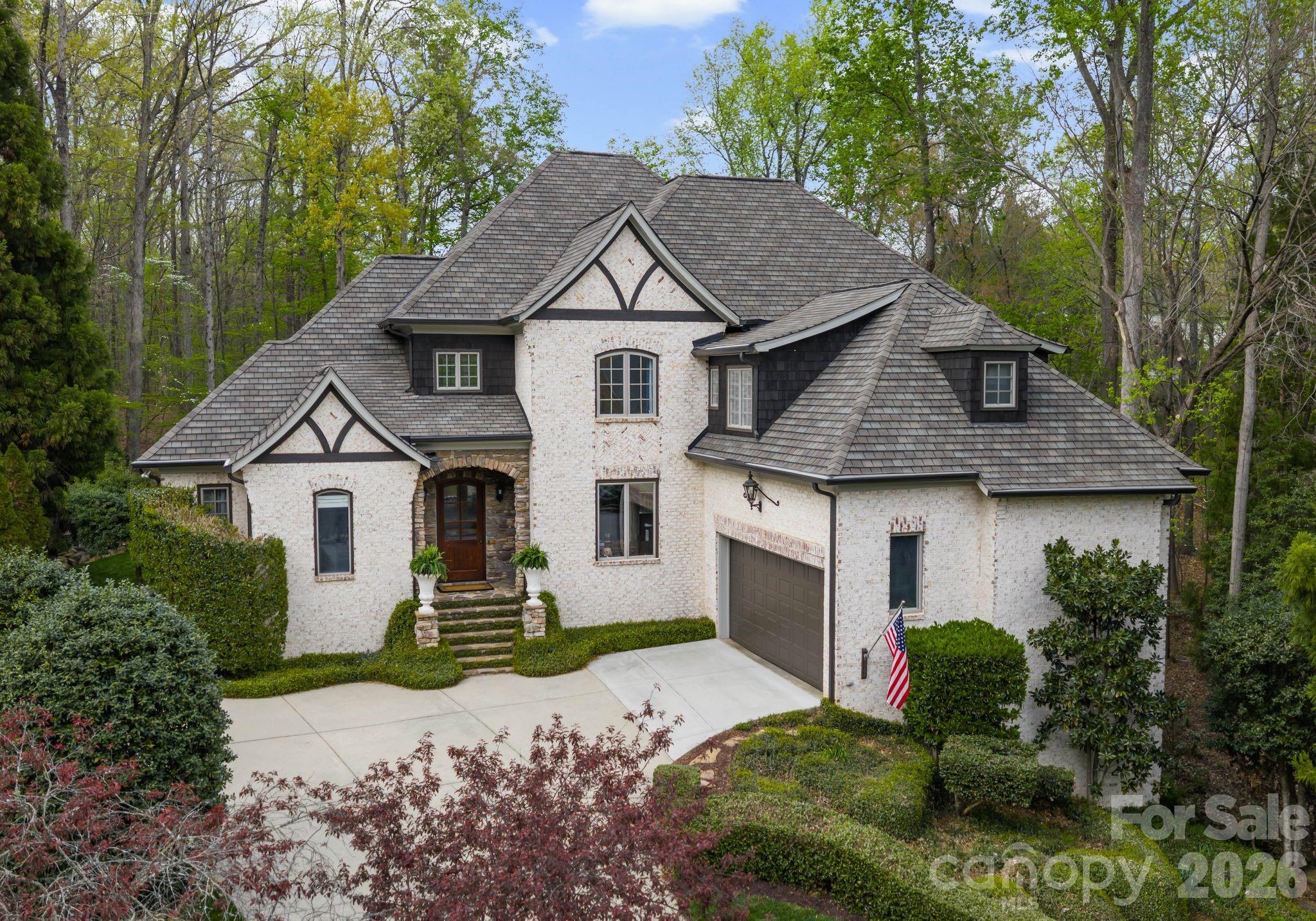 Custom-built executive home in sought-after South Charlotte location, just minutes from the charm of downtown Matthews, offering a rare combination of luxury living, timeless architecture, and a private resort-style setting tucked within a quiet cul-de-sac. Situated on a premium wooded lot with an expansive flat usable backyard, this one-of-a-kind retreat is designed for both effortless entertaining and everyday living.
This all-brick luxury residence features six bedrooms, expansive living spaces, and thoughtfully curated designer finishes throughout. Architectural details create an unforgettable first impression, including a dramatic 30-foot cedar tongue and groove ceiling, statement river rock fireplace with solid timber mantel, and a breathtaking two-story wall of windows that fills the home with natural light and seamlessly connects the indoors with the serene natural backdrop.
The newly remodeled chef’s kitchen was thoughtfully designed for elevated living and entertaining, featuring an oversized island, handcrafted Moroccan Zellige tile, designer lighting, and seamless flow into the breakfast area, keeping room, and screened porch overlooking the private backyard oasis. Main-level living spaces with soaring 10-foot ceilings provide exceptional indoor-outdoor flow and elevated views of the wooded setting.
The main-level primary suite offers privacy and convenience with spa-inspired potential and peaceful backyard views. Upstairs, three spacious ensuite bedrooms, a dedicated study area, bonus room, and second laundry room provide ideal flexibility for modern living.
The fully finished walk-out basement delivers exceptional multigenerational living and entertainer’s dream functionality with 10-foot ceilings, refined finishes, surround sound media area, spacious fitness room, kitchenette, guest suite, fireplace, flex room ideal for a wine lounge or music room, private office or additional bedroom, and direct access to the lower terrace and expansive backyard. This level functions beautifully as private guest quarters, an au pair suite, or independent multigenerational living space with private access.
Located within walking distance to highly rated schools including Providence High and Elizabeth Lane Elementary, and convenient to South Charlotte private schools, SouthPark shopping and dining, Uptown Charlotte, and all that Matthews has to offer.
Rarely does a home combine this level of privacy, architectural character, functional luxury, and expansive outdoor living in such a prime South Charlotte location. Thoughtfully designed and truly one-of-a-kind, this private retreat is best experienced in person. Located in Mecklenburg County.