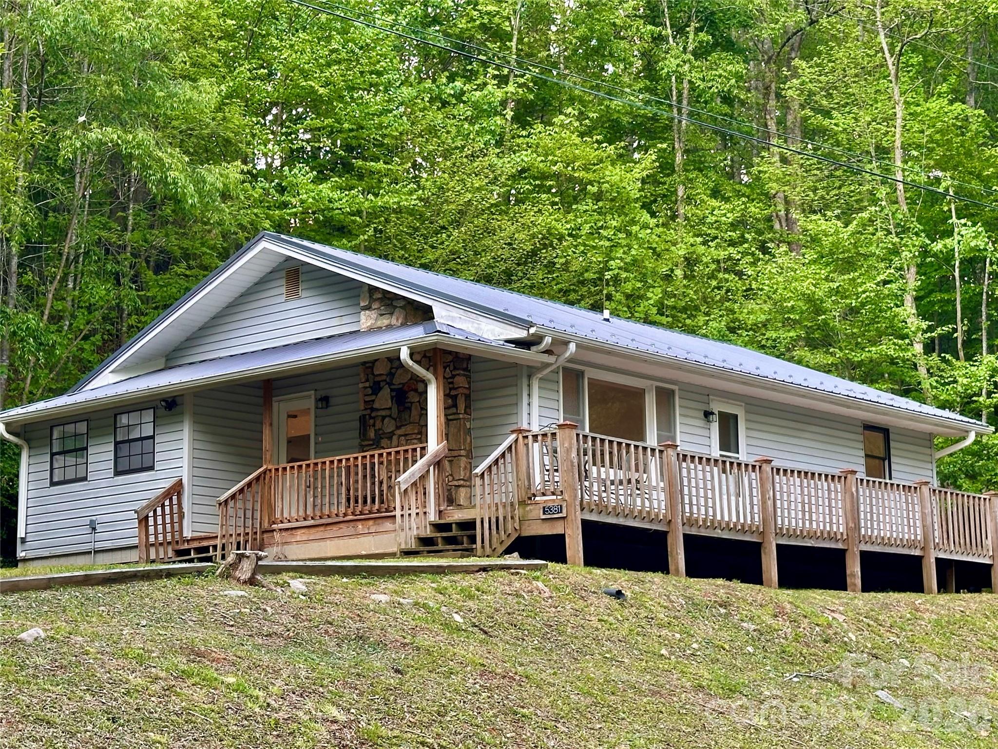 Another Price Drop – Now $3,000 Lower! This Treasure Just Got Even More Irresistible! Stunning, Unaffected River-View Retreat – Your Proven Safe Haven Awaits! Proudly Resilient & Completely Unaffected by Hurricane Helene. When Helene brought historic flooding to parts of the Cane River valley in September 2024, this home stood strong—high and dry with zero damage. Its smart elevation and solid build made it one of the true success stories along the river, untouched while the community has since fully rebounded: roads, bridges and river access restored, infrastructure repaired and the serene mountain lifestyle thriving once again.  Nestled serenely along the pristine Cane River, this captivating 2-bedroom, 2.5-bath gem with a versatile bonus/flex room perfectly blends modern comfort and breathtaking mountain tranquility. Inside, an open-concept living space bathes in natural light, featuring gleaming oak hardwood floors and a dramatic floor-to-ceiling natural stone fireplace as the cozy centerpiece. The chef-inspired kitchen flows seamlessly into the dining and living areas—ideal for lively gatherings, family meals or quiet evenings by the fire.  Step outside to a covered side porch and spacious open front deck, where you can unwind with stunning river and mountain views. Just moments away from the Cane River that invites you to dip your toes in the cool, clear waters —perfect for fishing, tubing or simply soaking in nature's beauty. Equipped with a durable metal roof, central HVAC and recent upgrades throughout, this Move-In-Ready retreat is truly turnkey—no surprises, just peace of mind.  Why wait or rent when you can own this peaceful paradise at an unbeatable price—now even more affordable after our latest $3,000 reduction? Imagine sipping your morning coffee on the porch, watching the gentle flow of the river and embracing the mountain life you've always dreamed of... in a home that's already proven it can weather the storm.  Prime location: Just 5 scenic miles to charming downtown Burnsville's cafes, art galleries and local shops; only 45 minutes to vibrant Asheville for culture, dining and amenities.  This rare survivor won't last long—act now and claim your riverside retreat in one of Western NC's most beautiful, recovering gems!