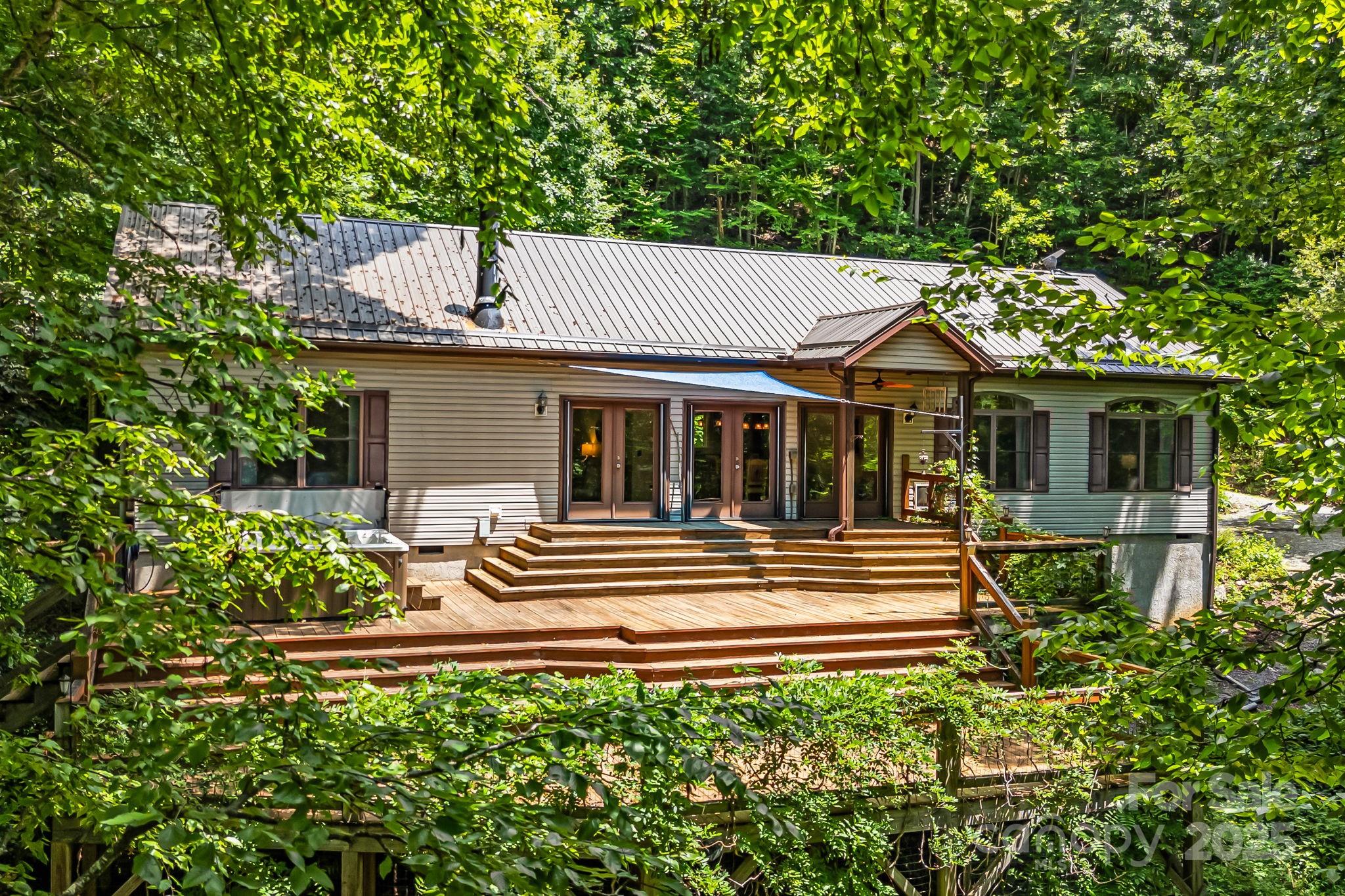 This property is fabulous! Imagine 10 plus acres, bold stream, with views & home in excellent condition aggressively priced at $625000! Spectacular private mtn estate embodies everything you ever dreamed of. Amazing ranch style home on 10+ priv. acres overlooking Newfoundland Mtn range. Wall of glass to enjoy nature's beauty year round. Tri-level deck, multiple stair levels to landscaped trails thru out. Walk to your own waterfall cascading down the rocks, fire pit or enjoy the mediation deck in the trees down by the creek. Gorgeous perennials abound. Immaculate Art & Crafts style home offers open flr plan, handsome hardwood floors & split BR plan. Primary BR w/charming bay window, tray ceilings, garden tub, sep. shower & huge walk-in closet. Spacious grt rm w/stone FP & wall of glass overlooking this amazing property. Opens onto lg. dining area & impressive lg. kit. w/island bar. Ideal layout for in-law suite w/sep. kitchenette. Fenced back area for pets, lg. detached carport & unfin. bsmt w/elec, ideal for storage and/or wkshop. Located in gated community in Upper Hominy Valley approx. 22 min. to downtown Asheville.