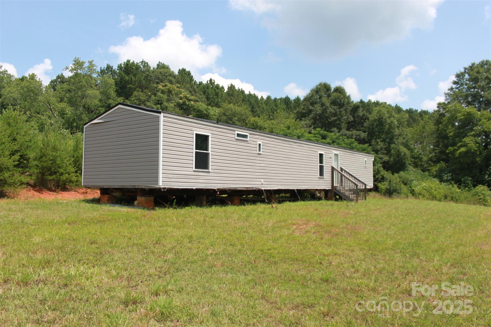 Charming 1994 Single Wide Mobile Home on 1.82 Acres. Discover your serene escape with this well-maintained 3-bedroom, 2-bathroom single-wide mobile home, perfectly positioned on 1.82 acres of peaceful land. Recent upgrades include new windows, modern bathrooms, a new water heater, stylish kitchen cabinets, a new island, and nice appliances. Enjoy the fresh look of new flooring, contemporary windows, and new light fixtures throughout.
This home requires some additional work, including the installation of a heat & air unit, underpinning, and removal of the tongue, as well as connection to the existing city water supply, Duke Power, and septic tank. With two septic systems already on the property, you'll have plenty of options for your plans. Please note this will be a cash sale only. Experience the tranquility of country living in a quiet setting that’s still surprisingly convenient to local amenities. Perfect for those looking to personalize their dream home!