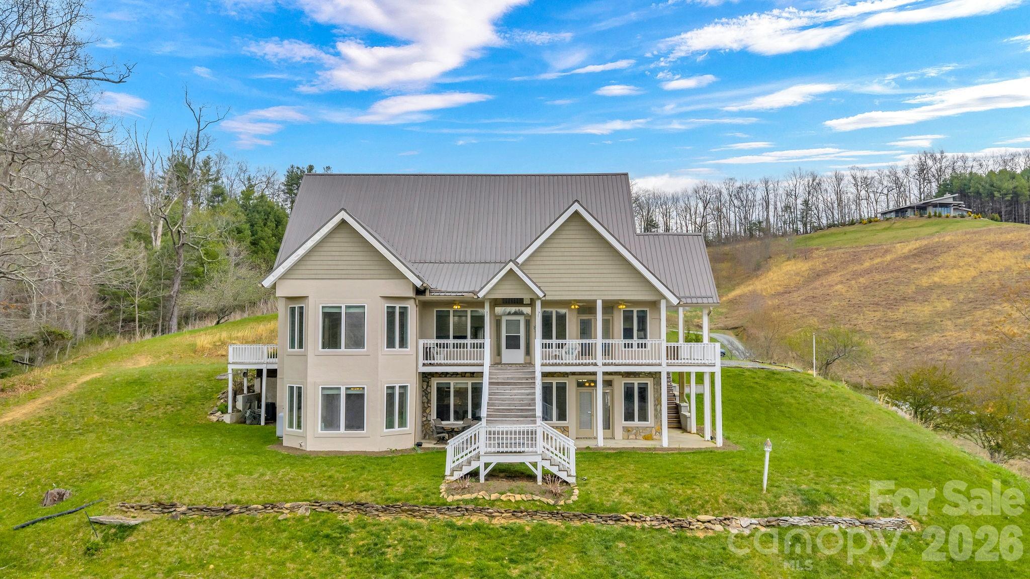 Tucked along the scenic New River, this expansive 5,850 sq ft home sits on 6.042 acres including river frontage, offering a unique combination of space, flexibility, along with beautiful landscape and views. Built in 2000 with ICF (insulated concrete form) construction, the home is designed for durability and energy efficiency. Featuring 4 bedrooms—3 with en-suite bathrooms—for a total of 4 full baths and 2 half baths in the home. Each of the three levels includes its own flex space. Both the main and lower levels feature open-concept designs, with full kitchens, living/dining space, creating excellent potential for extended living or guest accommodations. Step outside to take in both river and mountain views from multiple decks or from various areas across the property. Remaining furniture conveys with the home. Some deed restrictions will apply upon sale, and there are voluntary dues for Rustic Road Bridge maintenance.