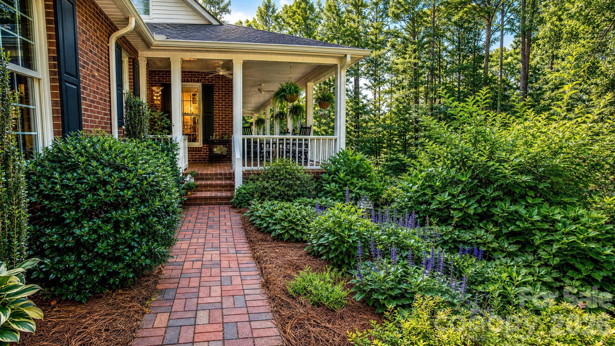 Some homes are built. Others are lovingly cultivated over time. Nestled on 3.5 private acres within a peaceful enclave of just twenty-four homes, this custom 1.5-story residence with F.R.O.G. offers a rare blend of privacy, timeless craftsmanship, and the natural beauty of the Blue Ridge foothills.

Lovingly maintained by its original owner since its completion in 1998, every space reflects thoughtful design and exceptional care. From the deep, welcoming brick-floored front porch spanning the width of the home to the hand-selected stone fireplace that anchors the living room, this is a home designed as much for quiet mornings as it is for memorable gatherings. Rich random-width ash hardwood floors, custom cherry cabinetry, granite countertops, a gourmet kitchen, walk-in pantry, built-in office, formal dining room, and a spacious main-level primary suite combine timeless elegance with everyday comfort.

Thoughtfully designed for both today’s living and tomorrow’s possibilities, the versatile floor plan offers exceptional flexibility. The main level provides true ease of living with the primary suite, a second bedroom, and two additional full bathrooms, creating comfort and privacy all on one floor. Upstairs, two additional bedrooms share a Jack-and-Jill bathroom and are complemented by a cozy gathering area in the hallway—an ideal space for reading, study, or quiet retreat. A cedar-lined walk-in closet adds a distinctive touch of craftsmanship and care. Additionally, over the garage is a spacious, finished living space with oak floors and pine ceilings.

Whether accommodating guests, supporting multigenerational living, creating dedicated office or hobby spaces, or simply adapting as needs change over time, this home offers a layout that evolves with its first next owner. Wide doorways throughout the main level further enhance accessibility while preserving the home's refined architectural character.

Outside, discover more of what truly sets this property apart. Nearly three decades of thoughtful stewardship have transformed the landscape into a living garden that offers beauty in every season. Heritage camellias, native flowering perennials, hydrangea, mature vitex trees lining the circular drive, and productive blueberry bushes create an ever-changing backdrop for butterflies, songbirds, and generations of hummingbirds that faithfully return each spring. This is not landscaping that can be purchased—it is a landscape that has been patiently cultivated.

Located just minutes from Lake James and within easy reach of the Blue Ridge Parkway, Pisgah National Forest, downtown Morganton, Asheville, and Charlotte, this home offers the rare opportunity to enjoy peaceful country living without sacrificing convenience.

For the next owner, 2086 Warrior Fork Trail offers more than exceptional craftsmanship and timeless design. It offers a sanctuary where mornings begin on the porch, evenings end beneath the stars, and every season brings something new to discover.