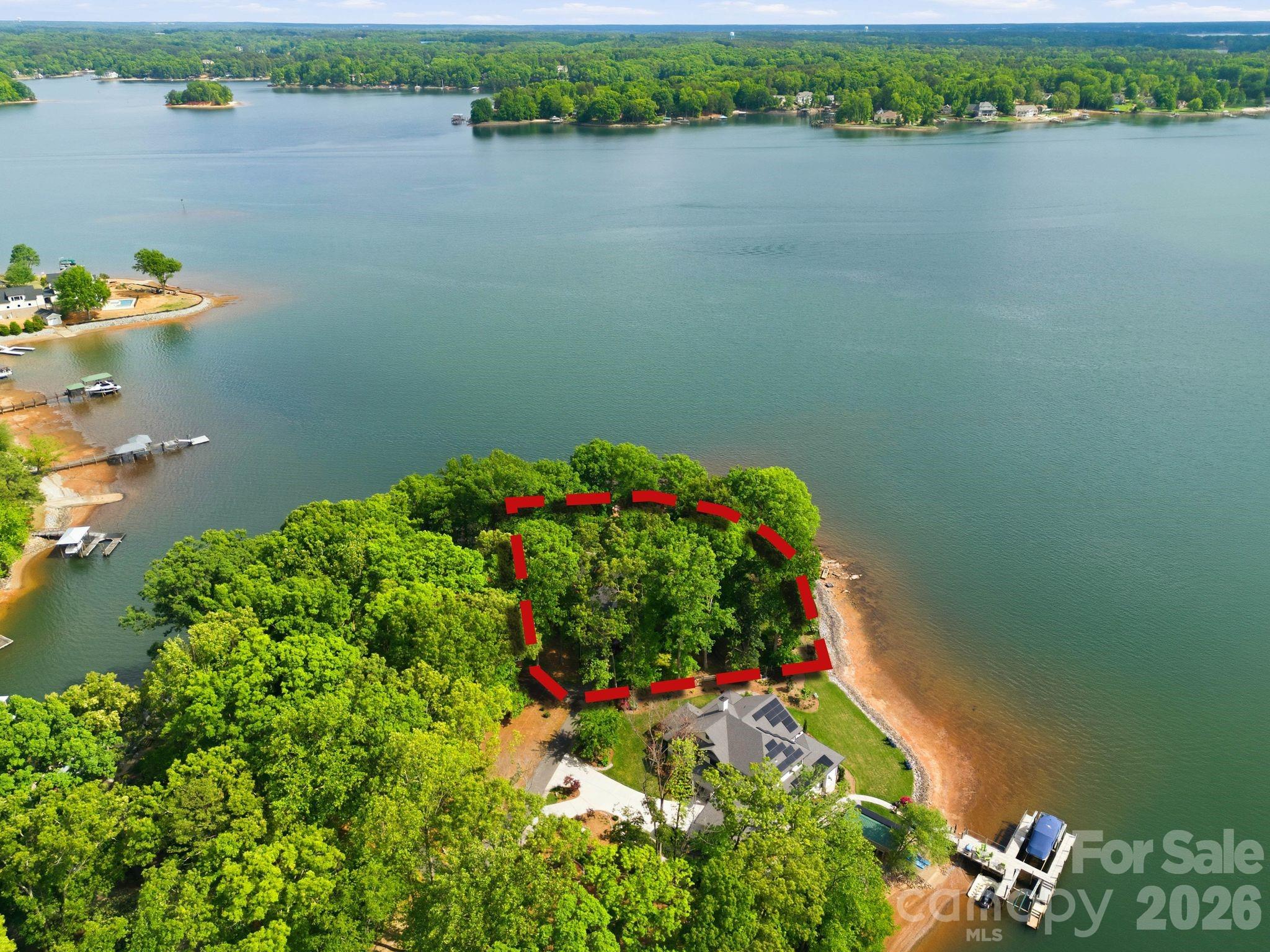 Positioned on a coveted stretch of waterfront, this distinguished residence is defined by its extraordinary setting and timeless appeal. Not many nicer views than this on Lake Norman. Encompassing approximately 3,000 square feet, the home offers four bedrooms, three full baths, office, and a versatile bonus room or additional bedroom overlooking the water, perfectly capturing the home’s most breathtaking views while balancing comfort, function, and enduring charm. At the heart of the home, a dramatic vaulted great room showcases rare wormwood-accented walls and an impressive stone fireplace, creating a warm yet striking gathering space. Expansive windows frame uninterrupted water views, while multiple living areas invite both quiet retreat and elegant entertaining. The primary suite is a private sanctuary, featuring dual walk-in closets and a spacious en-suite bath. Just off the primary bedroom, a dedicated office with a wet bar offers an ideal space for work or relaxation, all within steps of your own retreat. Outdoor living is equally compelling. A sprawling multi-level deck extends toward the water, complemented by two screened porches for year-round enjoyment of the serene surroundings. The private pier, complete with dock and gazebo, along with a dedicated boat launch, offers seamless access to the water, making every day feel like a getaway. The grounds are a true highlight, featuring a beautifully established rose garden and mature flowering landscapes that provide color, privacy, and a sense of tranquility throughout the seasons. A gated entrance and two-car garage further enhance the property’s exclusivity and convenience. Rich in character and set against breathtaking waterfront vistas, this is a rare opportunity to own a home where craftsmanship, natural beauty, and location come together in perfect harmony. Complete with an impressive 352 feet of pristine waterfront. Architecture by Dennis Lehmann of Banner Elk NC. Full Video Tour and Photos: https://listings.skycampictures.com/3725-Kingfisher-Ln-Terrell-NC-28682-USA?mls=