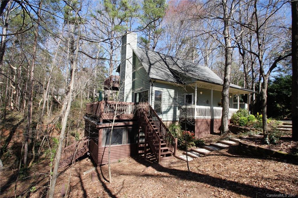 Wooded & seasonal lake view in Tega Cay! Great room with Brazilian Cherry wood floors, stone fireplace wooded views & deck. Kitchen with tile, white cabinets, granite, breakfast bar, & pantry. First floor bedroom & full bath. Upper level master with deck overlooking woods & 3rd bedroom with private bath.  Lower 4th bedroom with full bath, large Family/Bonus room, PLUS Office/Playroom/Work Out room. Beautiful Screened Porch leads to yard. Fort Mill Schools. Close to boat ramps & lake access.