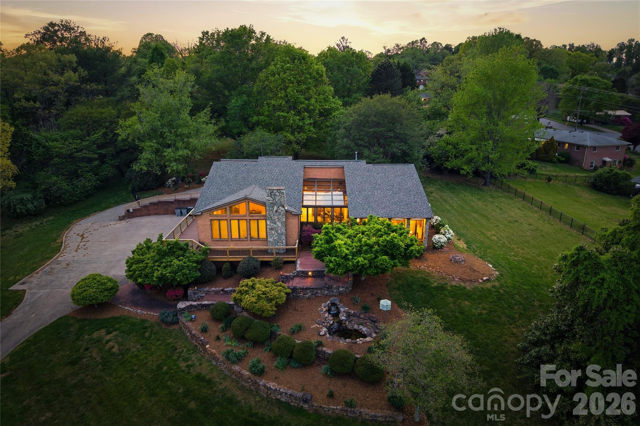 Nestled on over 10 stunning and flat acres, this property offers an extraordinary blend of convenience and tranquility!!

Located adjacent to the Lenoir Greenway and just minutes from downtown. Enjoy easy access to Highway 321, making trips to Boone and Blowing Rock a breeze. You can even stroll to the Greenway directly from your backyard, enhancing the appeal of outdoor living. The home features a brand-new wraparound back deck with durable Trex decking, perfect for entertaining or simply relaxing while enjoying the scenic surroundings.

As you enter, the inviting garden room welcomes you with large windows that frame picturesque views of Hibriten Mountain. Italian porcelain tile seamlessly extends into the kitchen and breakfast areas, complemented by exquisite built-in shelves and cabinetry throughout. The main level hosts a spacious primary suite, complete with a beautifully remodeled bathroom and a generous closet. Three additional bedrooms, a laundry room, and two more full bathrooms ensure ample space for family and guests. The home is open, bright, and charming throughout, creating a warm and inviting atmosphere.

The lower level features a fully equipped apartment with a kitchenette, an additional bedroom, living area, game room, and fitness space, along with a utility and storage room, all accessible from a four-car garage.

The backyard is a serene oasis, showcasing a back patio that overlooks a fenced-in yard, perfect for gatherings or quiet evenings. A larger detached garage complements the property, featuring a barn with a two-car garage and a built-in grease pit, ideal for car enthusiasts.

This property is a rare gem in the area, enhanced by beautiful landscaping and an abundance of natural light throughout the home. With its unique features, spacious layout, and prime location, this property is an unparalleled opportunity for those seeking a blend of rural charm and urban convenience!

There is an RV hookup in the detached garage and electric car charger/outlet in the attached garage.