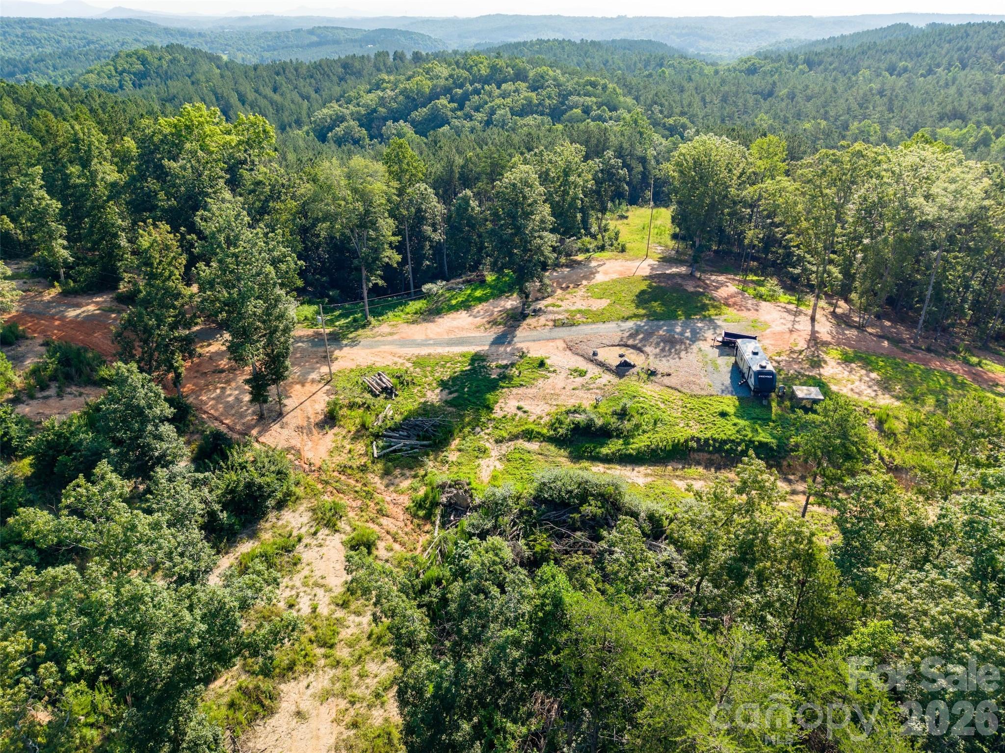 Explore this nearly six-acre parcel located on the county line between Rutherford and Polk Counties. A punched well and 3 bedroom septic are installed on site, as well as a camper with potential to convey. This parcel is wooded for excellent privacy. Less than 25 minutes to Chimney Rock, and 15-20 minutes to Mill Spring and Rutherfordton. DO NOT take neighbor’s drive to camper site. Park at Polk County Line Road and hike in.