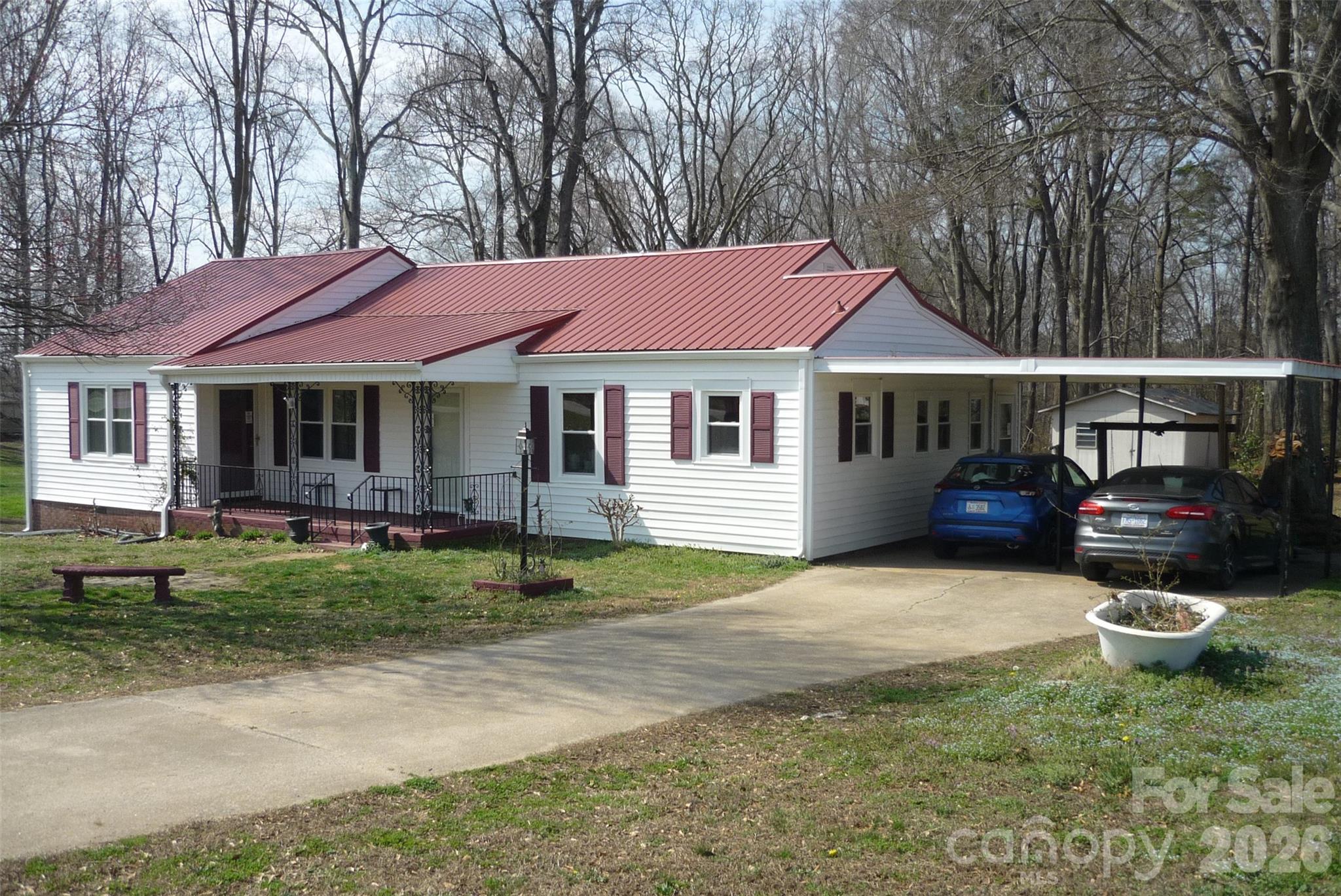 Come visit this 3BR, 2BA ranch home that sits on a 0.77 acre lot that backs up to the woods; From the cozy covered front porch to the new rear deck off the Primary Bedroom, this home has a modern layout with old school charm; The Kitchen has plenty of cabinets, a newer refrigerator and stove (2025) and a cozy dining area; Imagine entertaining your guests in the large Living Room; The Primary Bedroom has 2 closets, a new door to the rear deck and an updated full bathroom with a walk-in shower that was done in 2024; BR2 is quite large too and has a door to the covered front porch; The main bathroom has a new vinyl floor and a walk-in shower; Some newer laminate flooring; The side mudroom has the tankless Rinaii water heater in it as well as the washer and dryer, which are negoatiable; Updates that will give you peace of mind for years to come would be the metal roof (2025), the gutters (2025), insulated windows (2025) and the gas furnace (2020); There is a wall-mounted propane heater in the Living Room but there is no propane tank out back to hook up to and the seller has never used it; Enjoy the oversized 2 car carport; The home has county water but the old well is in the backyard - seller makes no representation about that; The attic is finished and is a great storage area; The crawlspace has a newer vapor barrier and a dehumidifier;
