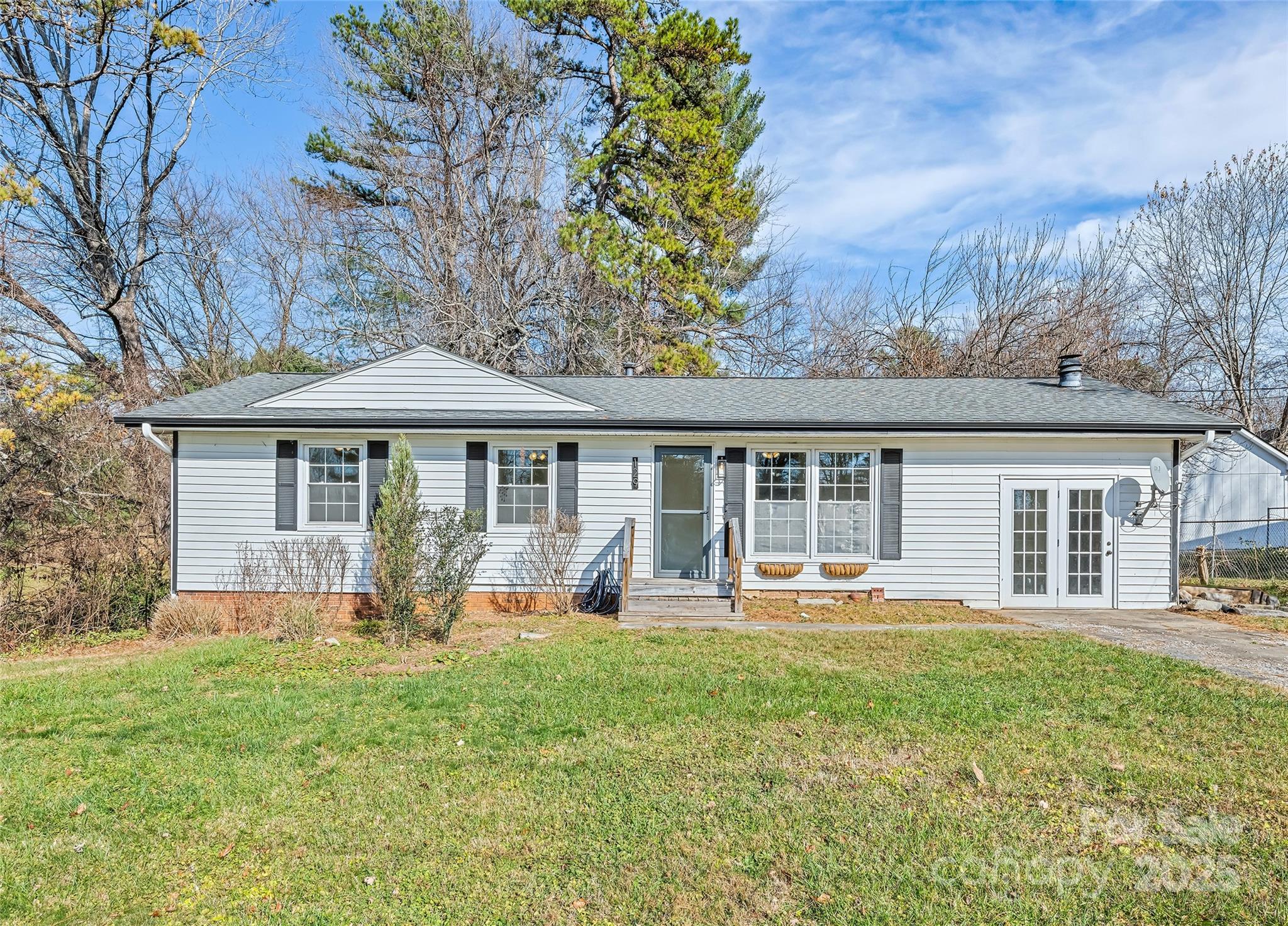 Enjoy the ease of main-level living in this beautifully updated home featuring 3 bedrooms, 2 full baths, and 1,333 sq ft of thoughtfully designed space on a level 0.25-acre lot. Built in 1973, the property has been modernized with luxury vinyl plank flooring throughout and a newly renovated spa-inspired primary bathroom. The kitchen offers a subway tile backsplash, stainless steel appliances, and abundant natural light. An oversized utility room provides flex space for storage or hobbies, while the modern fireplace creates a cozy focal point in the living area. Double French doors open to the backyard, seamlessly blending indoor-outdoor entertaining. Step outside to enjoy your fully fenced backyard, offering tons of privacy for gatherings, pets, or quiet relaxation. Additional upgrades include LeafFilter gutter guards with a transferrable warranty, ensuring low-maintenance living and long-term peace of mind. This turnkey home combines move-in ready convenience with timeless charm, making it ideal for buyers seeking the comfort and accessibility of single-level living. Located minutes from Hendersonville’s vibrant downtown, you’ll enjoy easy access to shopping, dining, and outdoor recreation—a perfect balance of lifestyle and location.