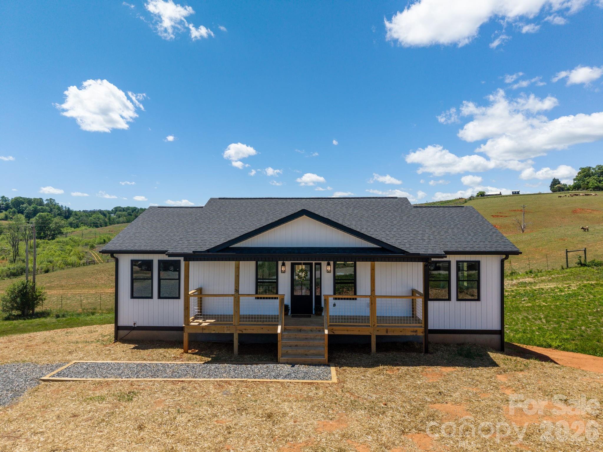 A great new construction build, recently completed, in the beautiful & pastoral Alexander area of Buncombe County. Less than 20 mins to Asheville, this home and property have the benefits of living in a country setting with the amenities of the city nearby. This newly built home features over 1400 sq ft of main-level heated living area with an open concept, split bedroom floorplan. The spacious open living area features vaulted, tongue & groove ceiling with plenty of natural light. The kitchen has lots of cabinets and hard-surface granite counters. The handcrafted, custom built island doubles as a breakfast bar and the dining area provides views while allowing direct access to the back deck. Enjoy daily sunsets over the adjoining pasture with West-facing views off the deck. There is also an expansive covered front porch, perfect for rocking chairs. One side of the main level features the Primary Bedroom with en-suite full bath. There is a very spacious walk-in closet and double vanity. The other side of the home has two bedrooms, a second full bathroom plus a nice sized dedicated laundry room with cabinets and sink. Take the stairs down to the unfinished walk-out daylight basement. Lots of opportunities here to expand the heated living area, make a workshop, home office and many other possible uses. This home is the last in the Agape Acres development, a quaint modern subdivision located just off Ridgeview Rd. The views coming home make it even better! This property is ready for it's new owner and easy to show - schedule your private showing today! See the property video here: https://derek-goodwin-photography-llc.aryeo.com/videos/019e335c-4062-71af-8d44-a26ac506573c and make sure to take the Virtual Tour here: https://my.matterport.com/show/?m=4oET9GX6y4V&