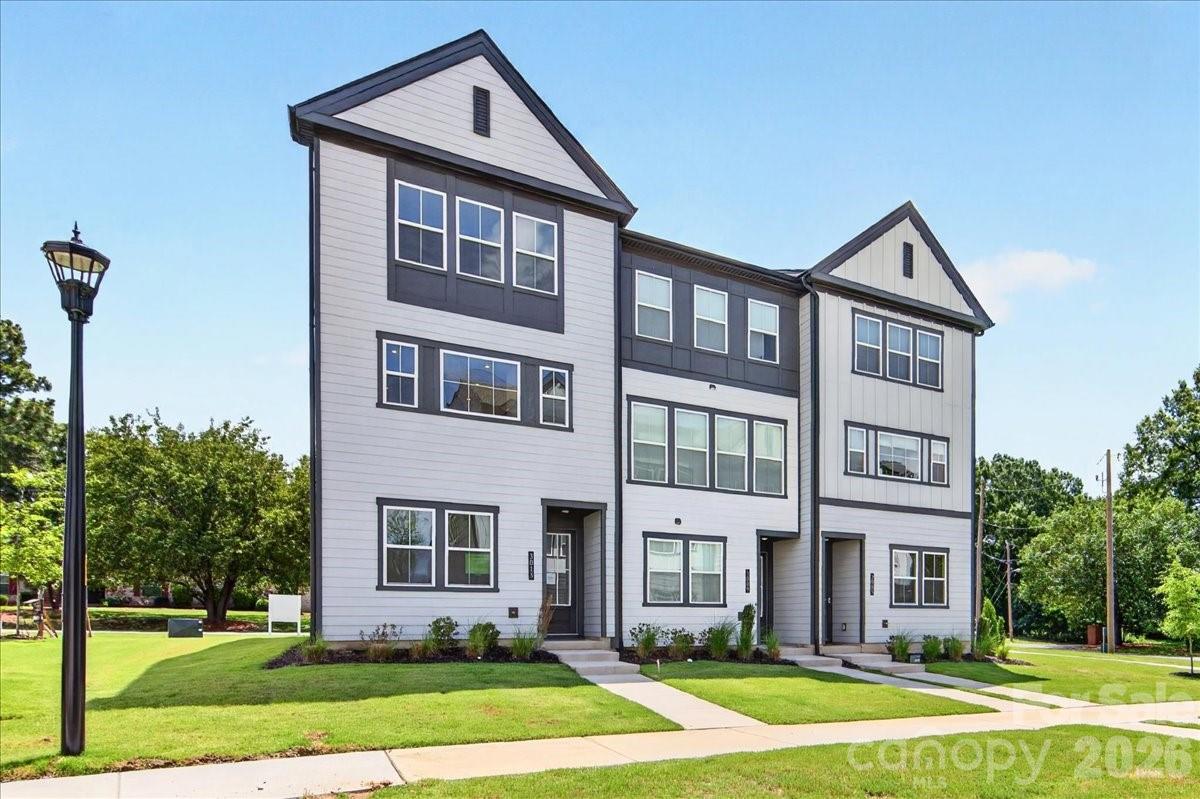 Located in the heart of South Charlotte, 3013 Circles End is a Paloma plan end unit townhome at Bellflower offering 3 bedrooms, 2 full bathrooms, 2 half bathrooms, and 2,080 square feet of thoughtfully designed living space with a 2-bay tandem garage. Tucked near the back of the community, this home sits steps from the dog park and guest parking. The entry level features a flex space ideal for a home office or guest room, a powder room, and oak box stairs with open rails leading to the heart of the home. The second floor opens into a bright, open-concept living area enhanced by added end unit windows that flood the space with natural light. The gourmet kitchen anchors the front of the home with warm brown cabinetry, white quartz countertops, a GE 36" electric cooktop, a single-bowl stainless steel sink with a Delta Essa Touch faucet overlooking the outdoors, and a central island with ample counter and storage space. At the rear, an 8-foot-tall, 12-foot-wide sliding glass door opens to a covered outdoor living space, perfect for entertaining. A powder room completes the second floor. Upstairs, the primary suite features a dual-vanity bathroom with a tiled walk-in shower, warm brown cabinetry, white quartz countertops, and a walk-in closet. Two additional bedrooms share a well-appointed secondary bathroom. Minutes from SouthPark, the Arboretum, and highly rated schools, Bellflower brings together comfort, convenience, and connection.