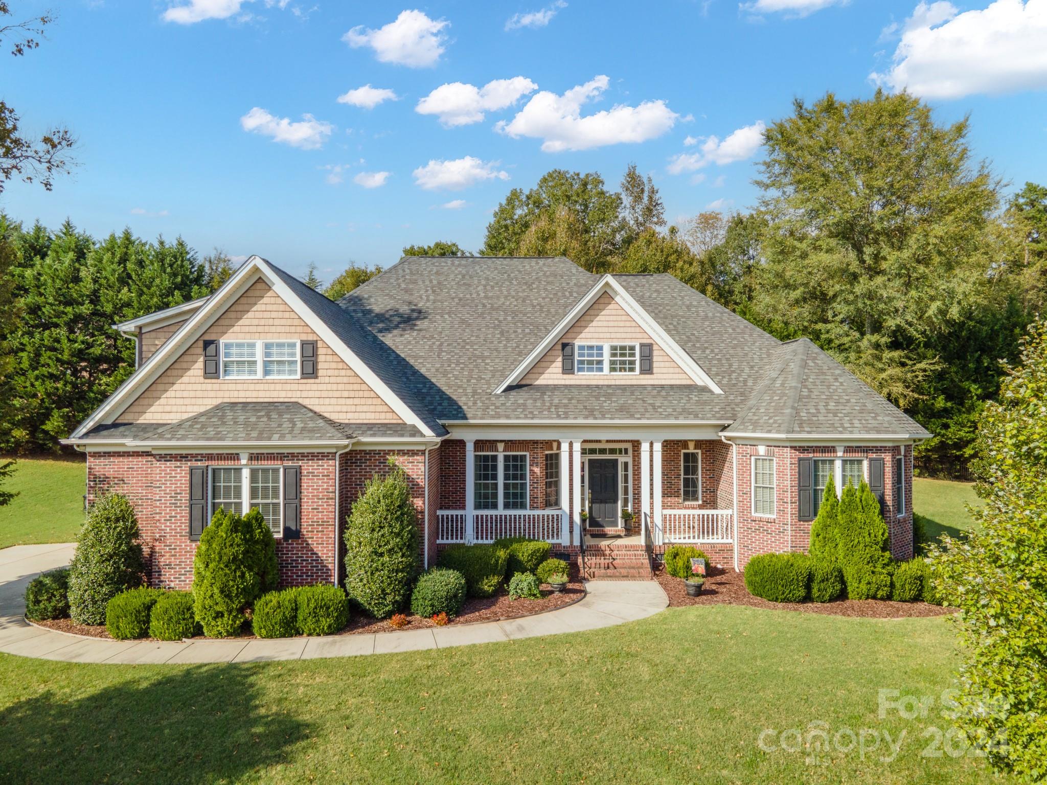 Beautifully designed 1 1/2 story home situated on over an acre of land, featuring a mostly brick exterior that exudes timeless charm. The lovely floor plan includes tall ceilings, creating an open and airy atmosphere. The kitchen invites any chef boasting granite countertops, a glass-top stove, ample cabinetry & a pantry with convenient pull-out shelves for easy organization. The Great Room serves as a focal point, featuring a cozy fireplace flanked by custom shelving, perfect for displaying your favorite decor or books. The primary bathroom is a true retreat, offering a luxurious walk-in shower, a freestanding tub, dual sinks, and dual closets for ample storage. Upstairs, your Bonus Room awaits, perfect for an office or playroom. Step outside to enjoy a large inset porch, perfect for entertaining and a handy shed for additional storage. The community features a lovely picnic area, providing the perfect spot for outdoor gatherings.  Fiber optics are available for high-speed internet.