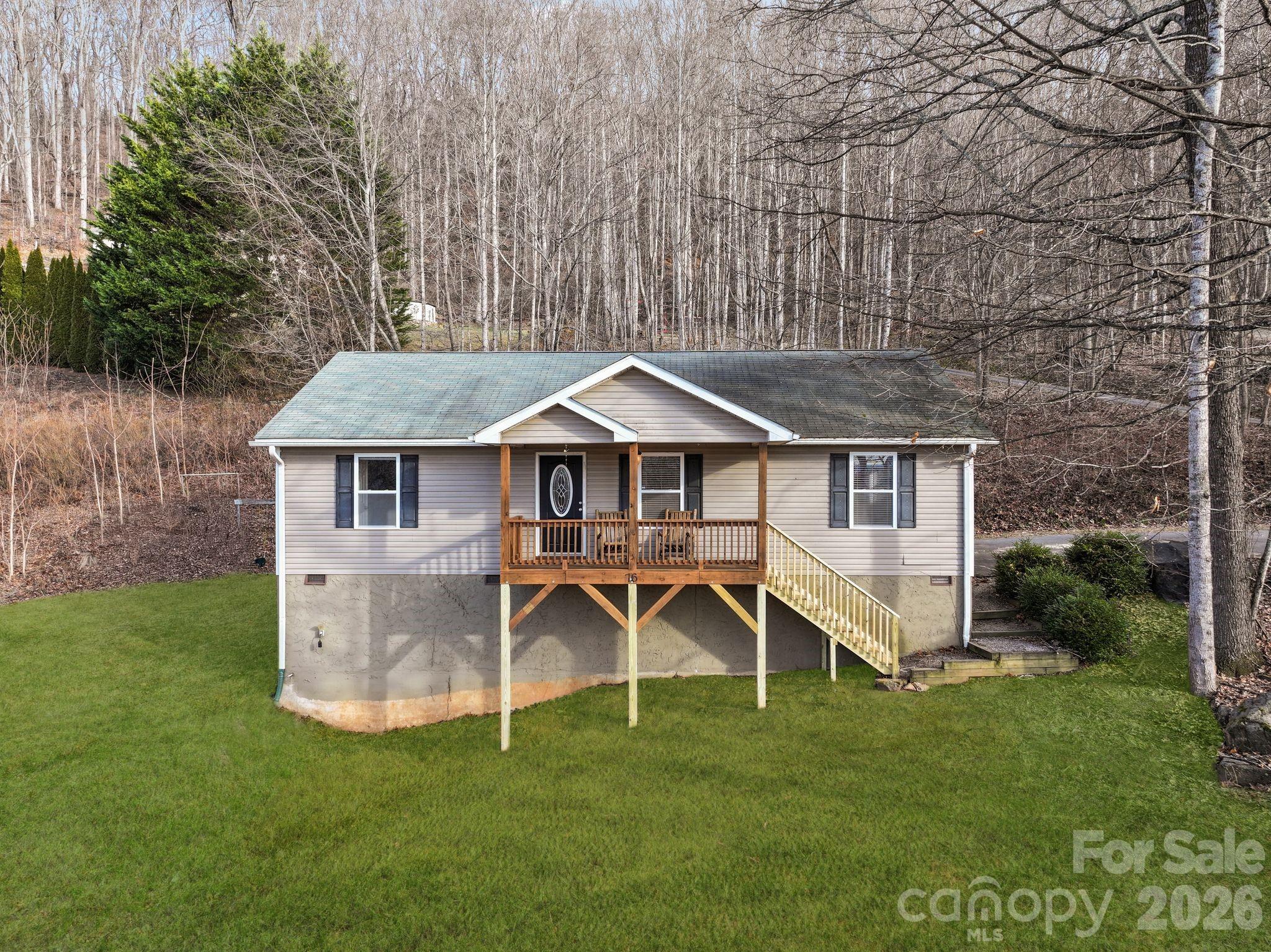 Mountain charm minutes from Asheville. Move-in ready and thoughtfully designed for easy one-level living, this Swannanoa home offers privacy and mountain views situated on an expansive lot. The desirable split-bedroom floor plan and open-concept living area is comfortable and functional with a spacious, well-appointed kitchen featuring new appliances and eat-in dining area. A gas fireplace anchors the living room, adding warmth and character to the home’s main living space.

The primary bedroom with ensuite bathroom features heated tile floors. Enjoy morning coffee with mountain views on the recently updated covered front porch surrounded by nature. The yard offers plenty of room to spread out, including a fire pit area that’s ideal for evenings outside.

With a successful short-term rental history and the option to be sold furnished, this property offers excellent flexibility as a primary residence, second home, or investment opportunity. Convenient to I-40 for easy access to Asheville, Black Mountain, and beyond.