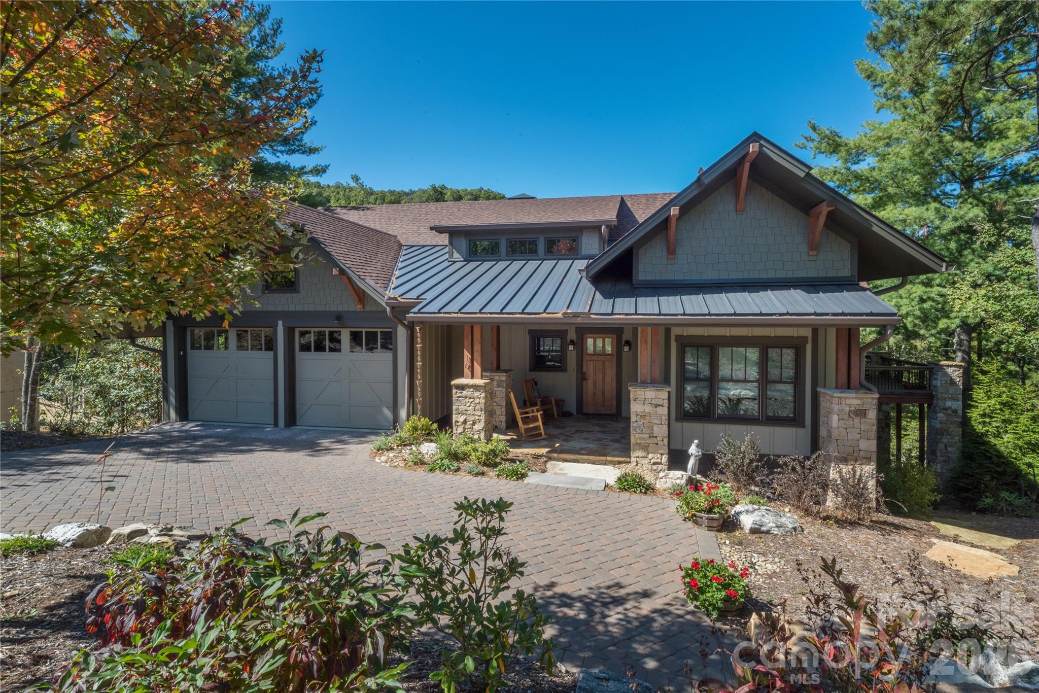 Experience the perfect blend of luxury and ease in this immaculate craftsman cottage located within The Settings of Black Mountain, a premier gated community just minutes from the heart of downtown. Built by the award-winning LivingStone Construction, this home is masterfully designed for low-maintenance, age-in-place living without sacrificing style. The main level impresses with soaring tongue-and-groove wood ceilings, elegant beams, and rich oak floors that lead you through an open floor plan bathed in natural light. A cozy gas fireplace anchors the living space, while the versatile second bedroom serves equally well as a professional home office. Transitions between indoor and outdoor living are seamless, with the main level opening onto a massive covered side deck that serves as a private sanctuary for every season.

The lower level is a masterclass in functional design, featuring Superior concrete wall construction and impressive eleven-foot ceilings. This daylight basement includes a kitchenette and family room that function perfectly as a guest suite, media room, or social hub, opening directly to a second private deck and a secluded hot tub area. Additionally, a sprawling storage room offers nearly five hundred square feet of potential, ready to be transformed into a home gym, art studio, or extra bedroom. Modern comforts are integrated throughout, including Windsor windows, a tankless natural gas water heater, a whole-house air purifier, and a built-in humidifier. There is also a massive attic storage area above the garage. Whether you are returning from a day of pickleball at the nearby Creekside Sports Club or a mountain hike, this home offers a sophisticated yet comfortable retreat in one of Western North Carolina's most sought-after settings.