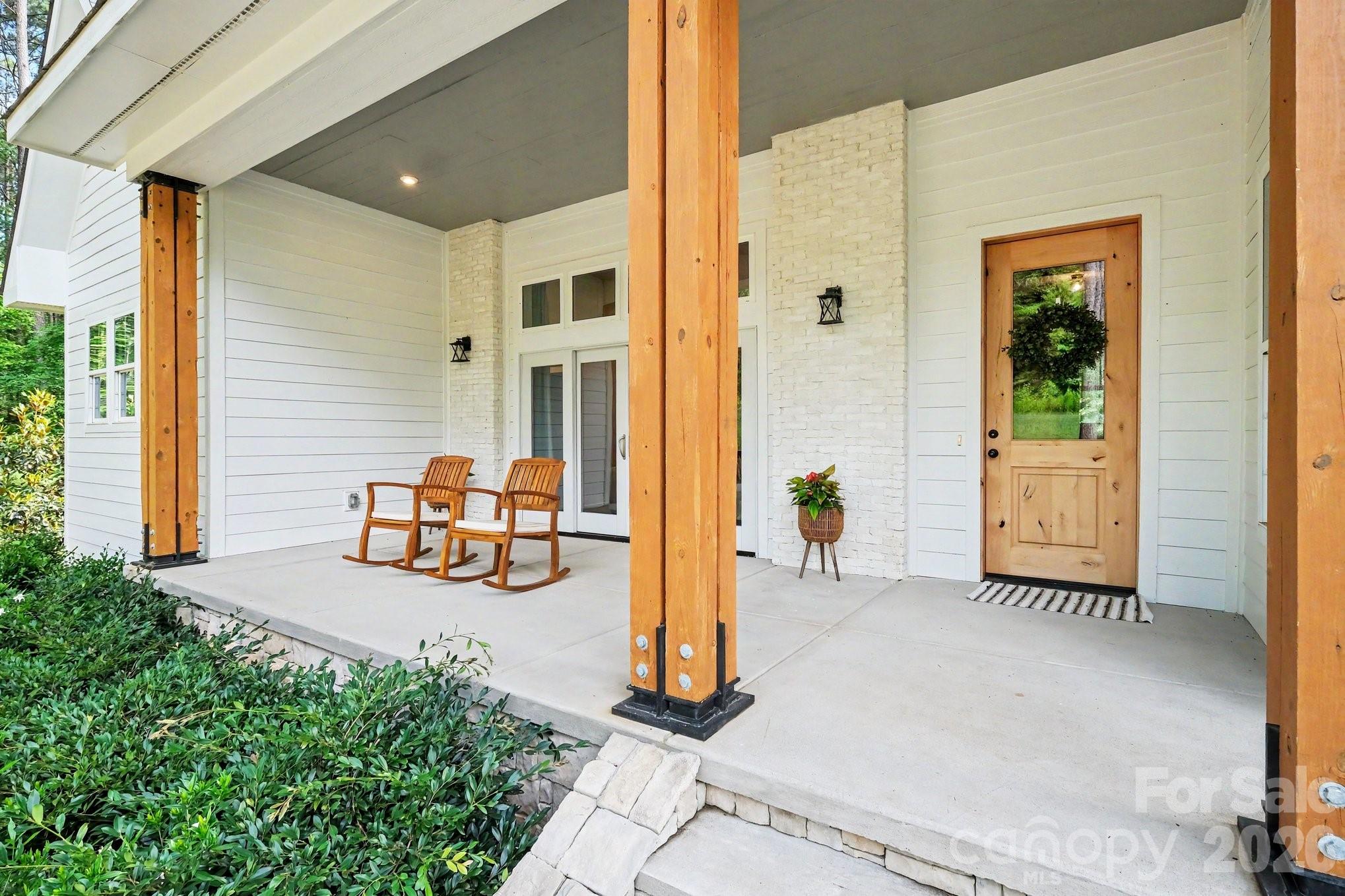 One of a kind lifestyle in the gorgeous home! Exceptional flexibility with this layout and serene wooded backyard privacy. The striking exterior showcases low maintenance white siding accented by warm wood columns, stone details, brick, double front doors, and modern black lighting. Inside, an open and airy floor plan is filled with natural light and highlighted by soaring ceilings, designer lighting, and wide-plank rustic wood flooring sourced from trees harvested on the property. 
The great room living space flows seamlessly from the front porch to the rear covered porch, creating ideal indoor-outdoor living expandable for entertaining. The chef’s kitchen features a bold center island with butcher block countertop and bar seating, quartz countertops, subway tile backsplash, five-burner gas range with hood, convenient butler’s pantry with wine fridge, and a walk-in pantry. An adjacent dining area completes the open-concept design.
The main-level primary suite is a slice of heaven with cathedral ceilings accented by wood beams, direct access to the rear patio, and peaceful wooded views. The windows allow lots of natural light without compromising privacy. The premier ensuite bath includes dual vanities, a soaking tub, and a tiled walk-in shower. A private office, spacious mudroom with built-ins, laundry area, and oversized side-entry garage complete the main level. Upstairs, a versatile loft provides additional living space alongside three generously sized bedrooms. Two bedrooms share a Jack-and-Jill bath, and a dedicated craft/storage closet adds convenience.
A standout feature of the home is the separate bonus living area with private rear entrance, offering exceptional flexibility for guests, multigenerational living, a studio, office, or recreation space. The lower level features impressive 14-foot ceilings and lounge space, while the upper level includes a kitchenette, dining area, and full bath.
Outdoor living is equally impressive with a covered rear porch featuring a stone fireplace, multiple seating areas, and expansive backyard space with mature landscaping, garden area, and lush tree canopy for added privacy. A full cabana bath off the porch and ample room for a future in ground pool to further enhance the property.
Residents of Riverchase Estates enjoy the peace and quiet of this location along with the resort-style amenities including a The clubhouse at Riverchase Estates which is part of a $4.5 million world-class amenity center, which includes a state-of-the-art fitness center, a resort-style pool, and a ballroom. It is designed for socializing and community meetings, making it a central feature of the community. The amenities include basketball, tennis, pickle ball courts, picnic area, playground, pond, street lights, walking trails and 500 acre nature preserve and access to the Catawba River, all conveniently located less than 15 minutes from shopping, dining, and everyday conveniences in Indian Land. If you are looking for a new lifestyle - come explore this opportunity today!